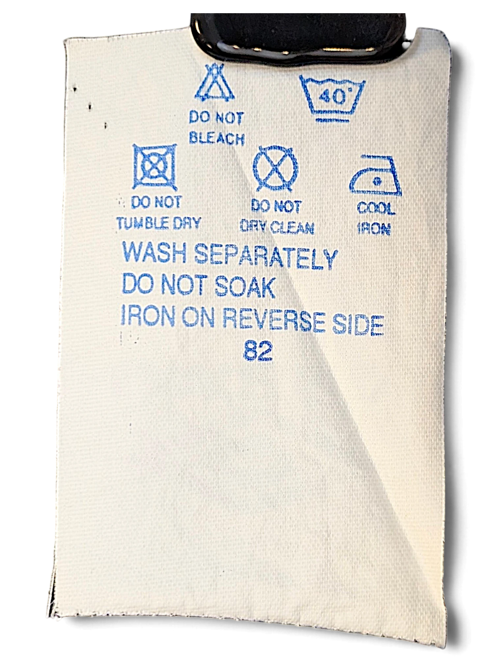JAKE & IPI Umbro track pants care label with washing instructions and symbols on white fabric