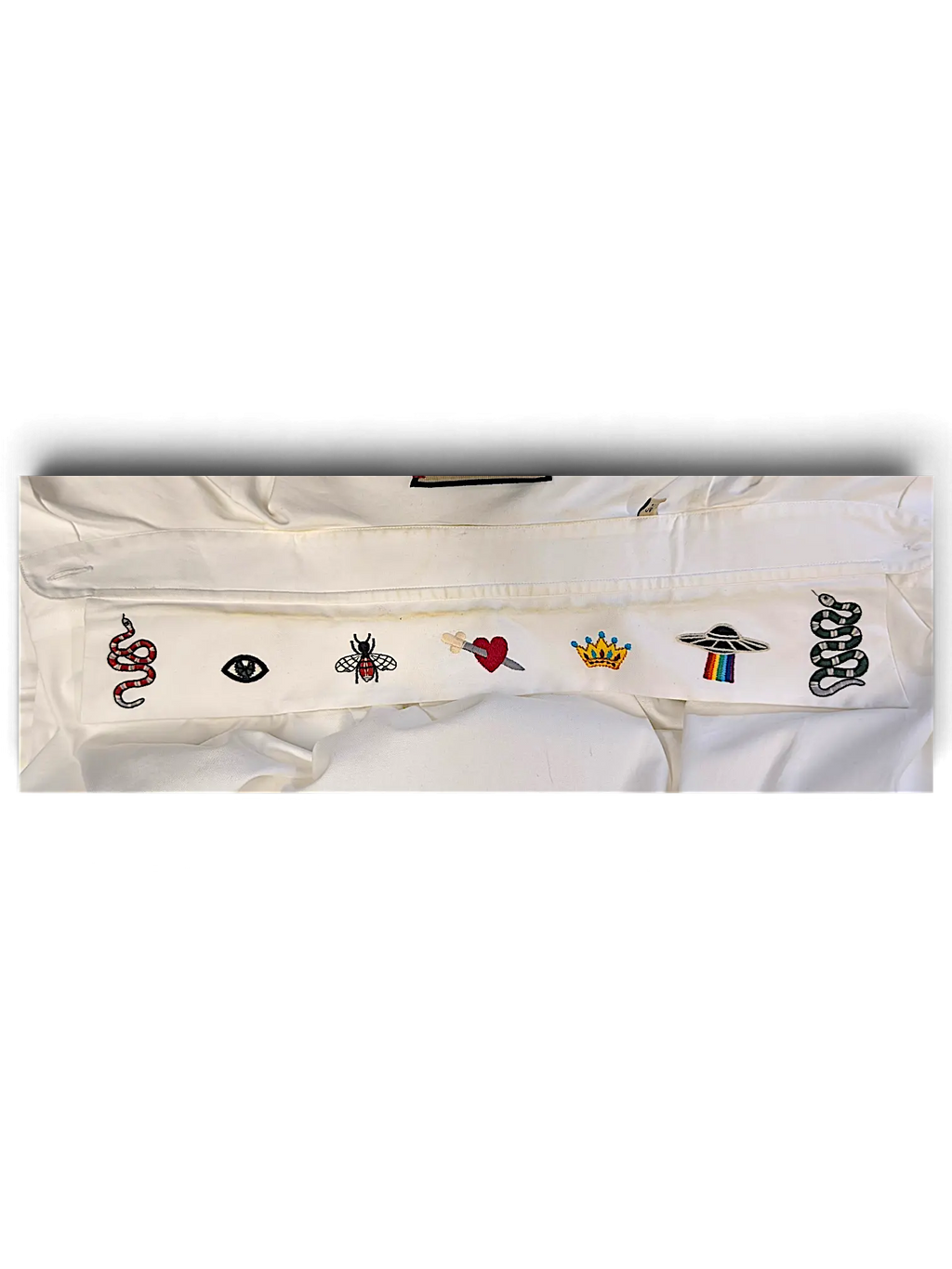 JAKE & IPI white IBE Gucci shirt featuring embroidered patches of a snake, eye, bee, heart, crown, and UFO.