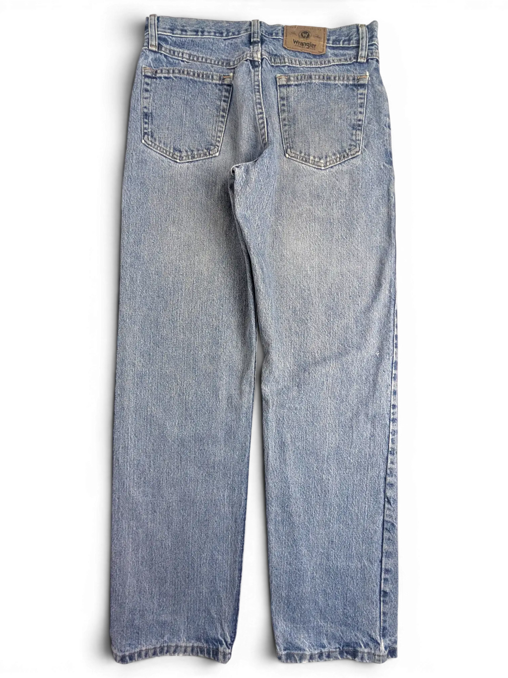 JAKE & IPI Wrangler light wash denim jeans with back pockets and leather brand patch on a black background