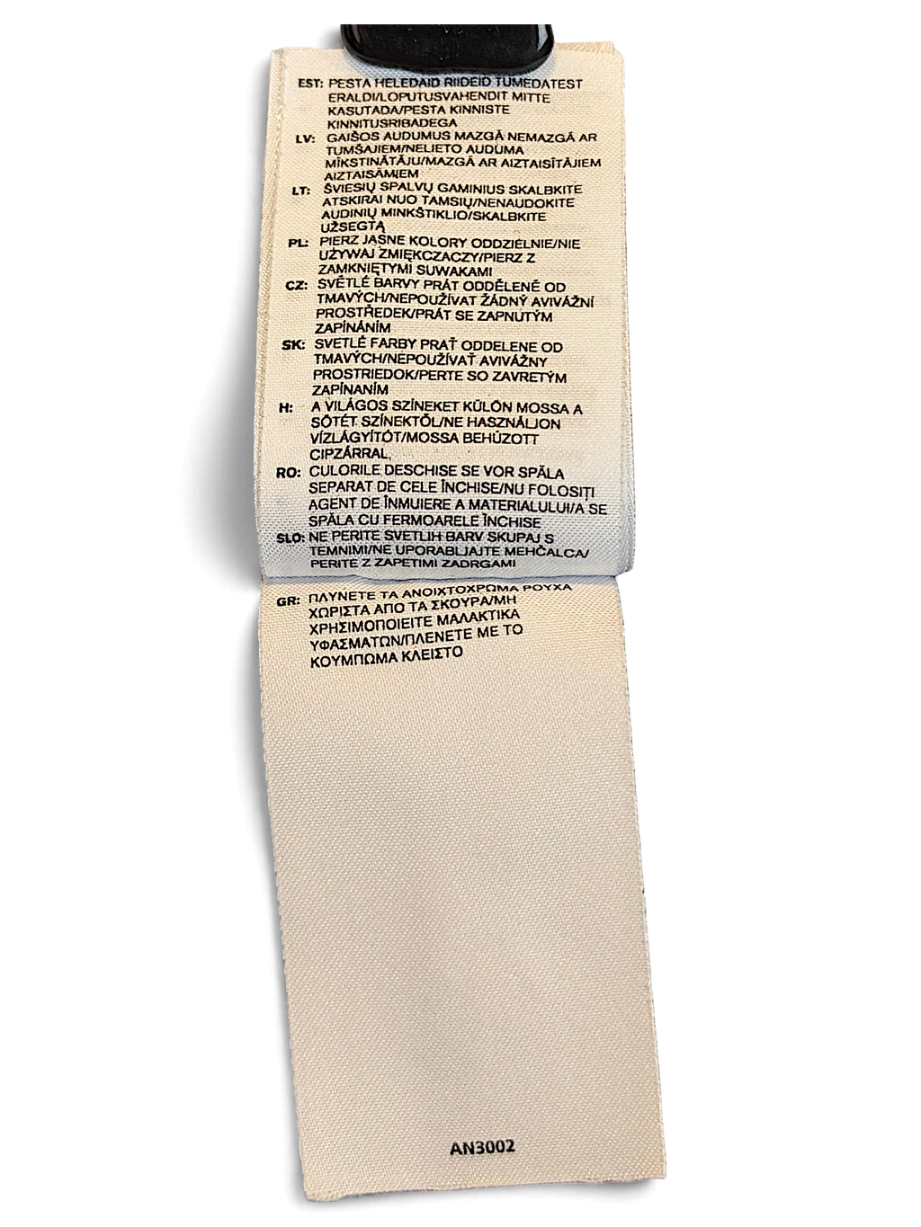 JAKE & IPI adidas track pants care label with multi-language washing instructions on a white fabric tag