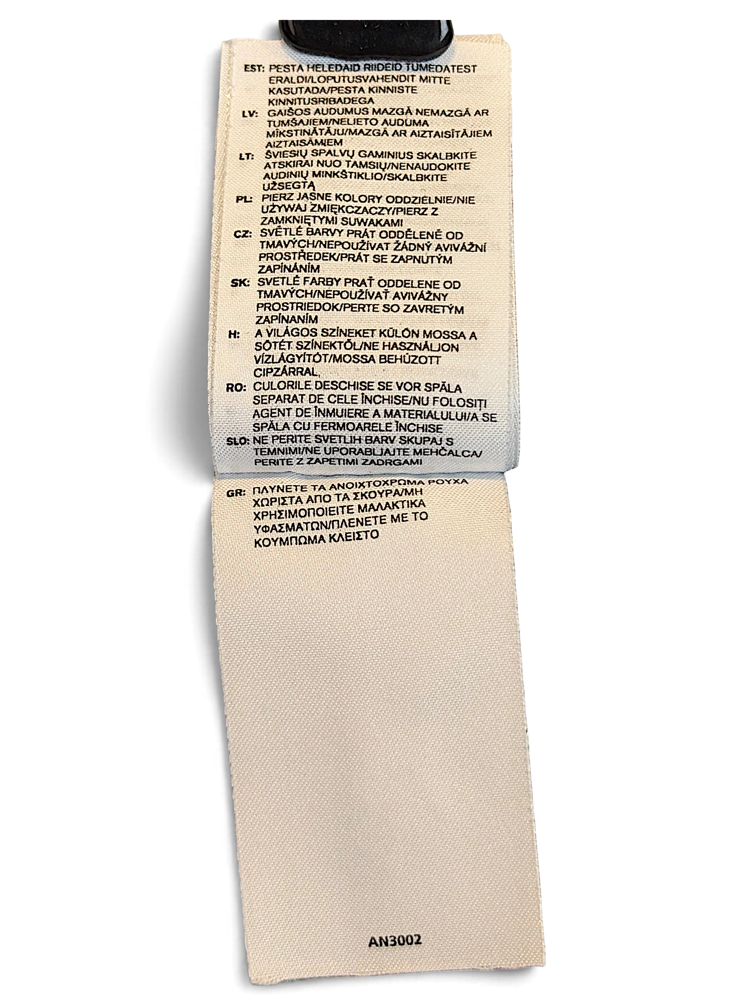 JAKE & IPI adidas track pants care label with multi-language washing instructions on a white fabric tag