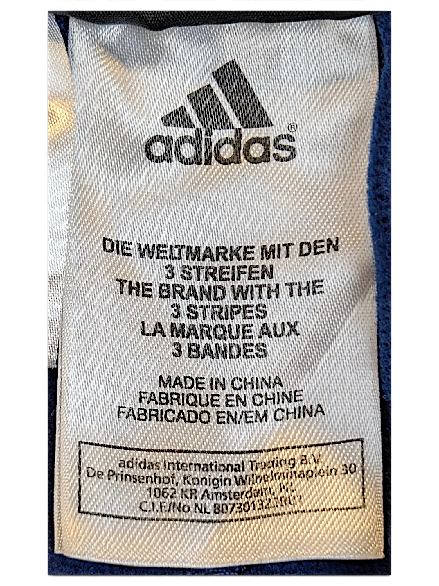 JAKE & IPI adidas track pants white fabric care label with brand logo and manufacturing details