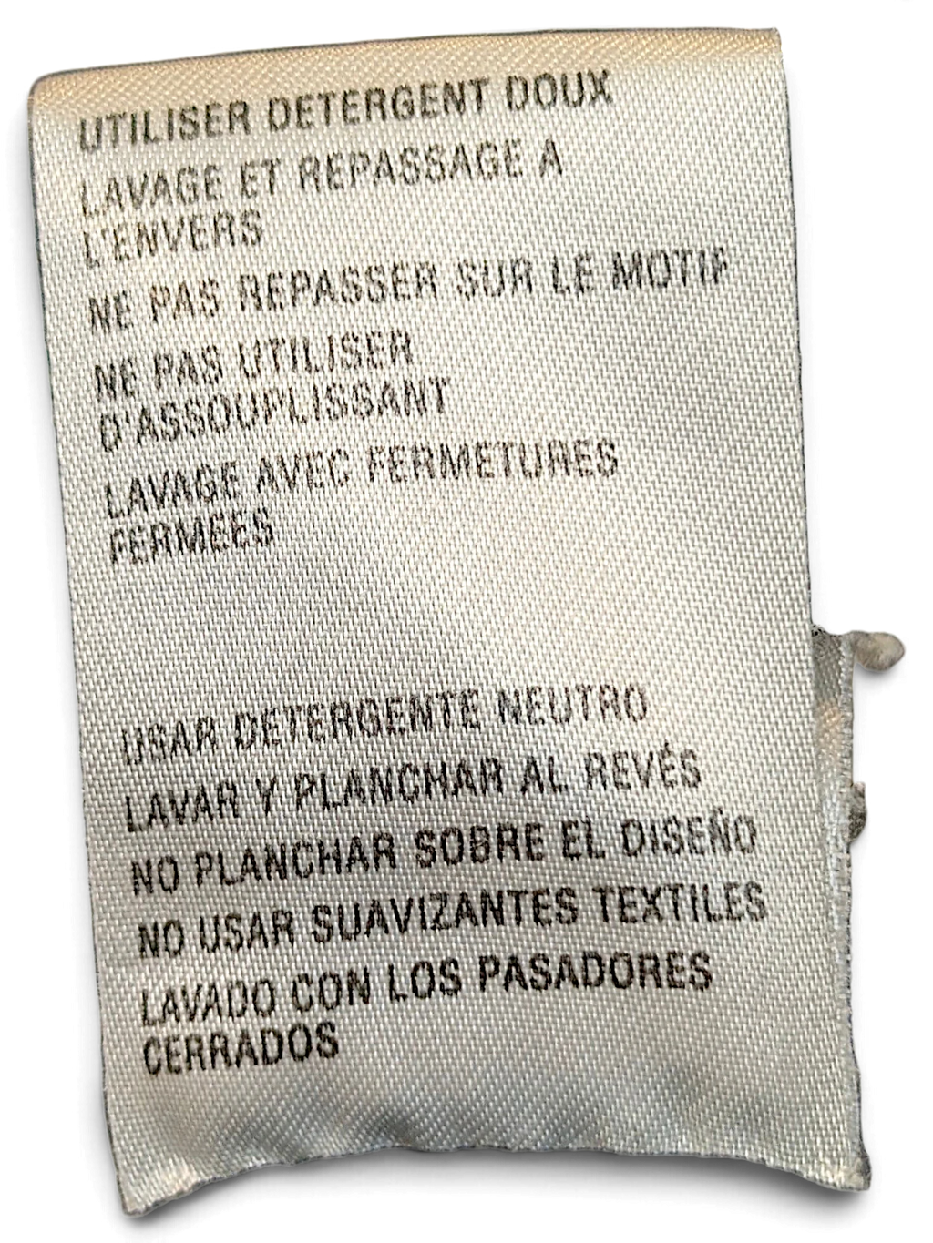 JAKE & IPI care label for adidas track pants with washing instructions in French and Spanish