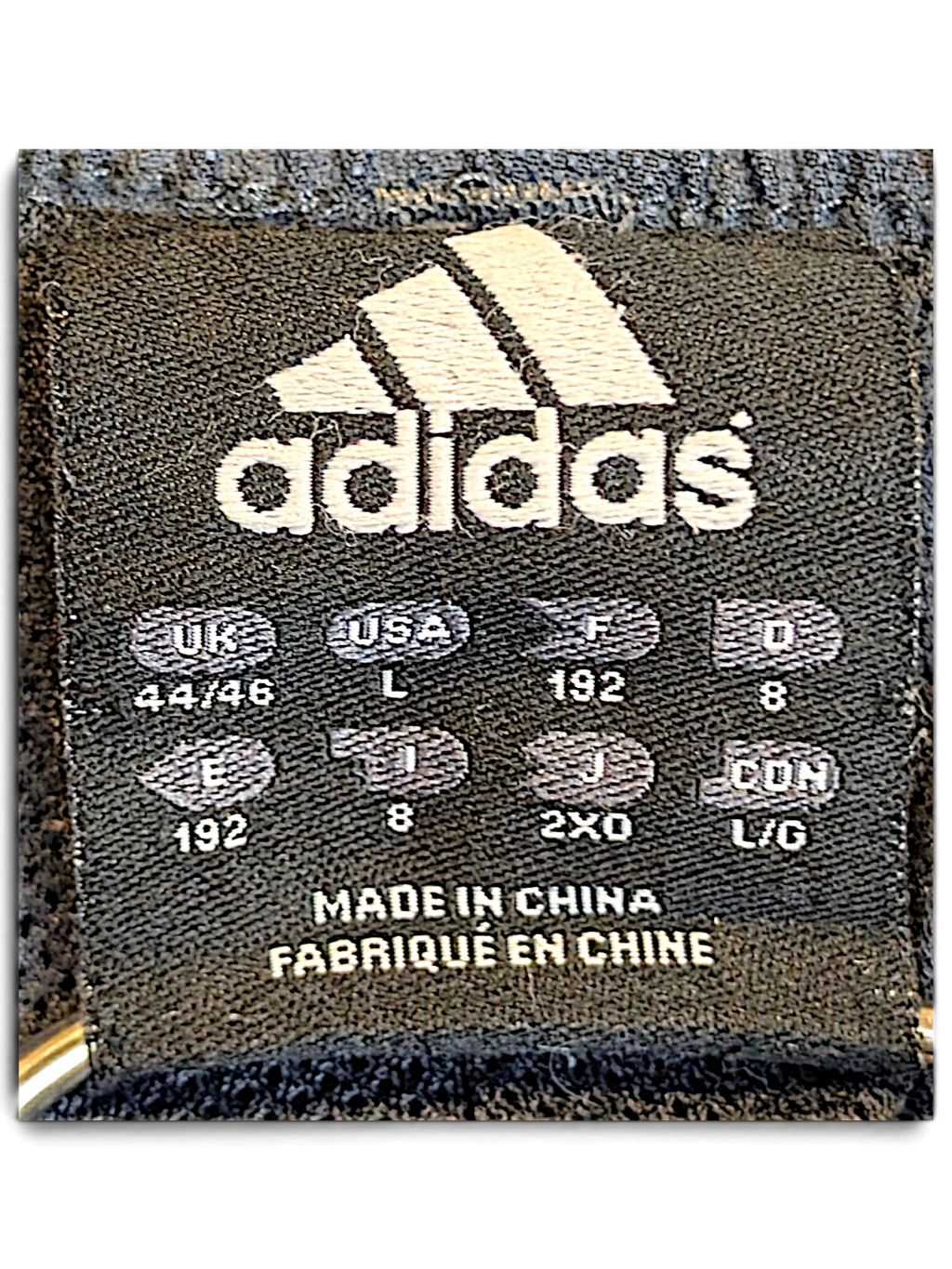 JAKE & IPI adidas track pants size L clothing label with international sizing information and made in China text