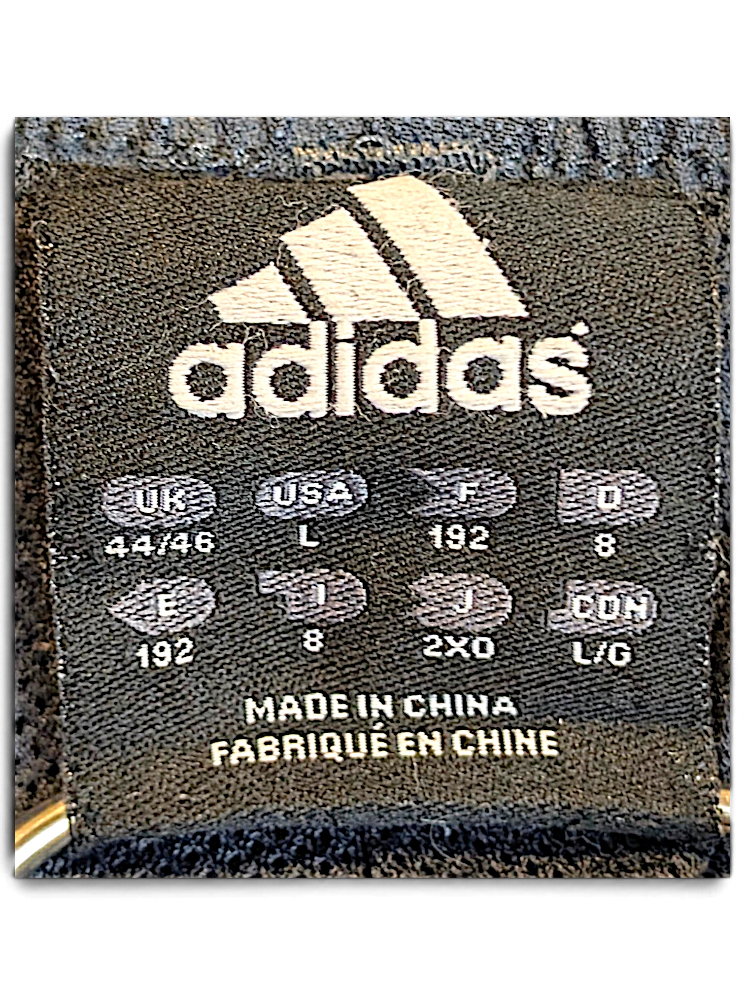 JAKE & IPI adidas track pants size L clothing label with international sizing information and made in China text