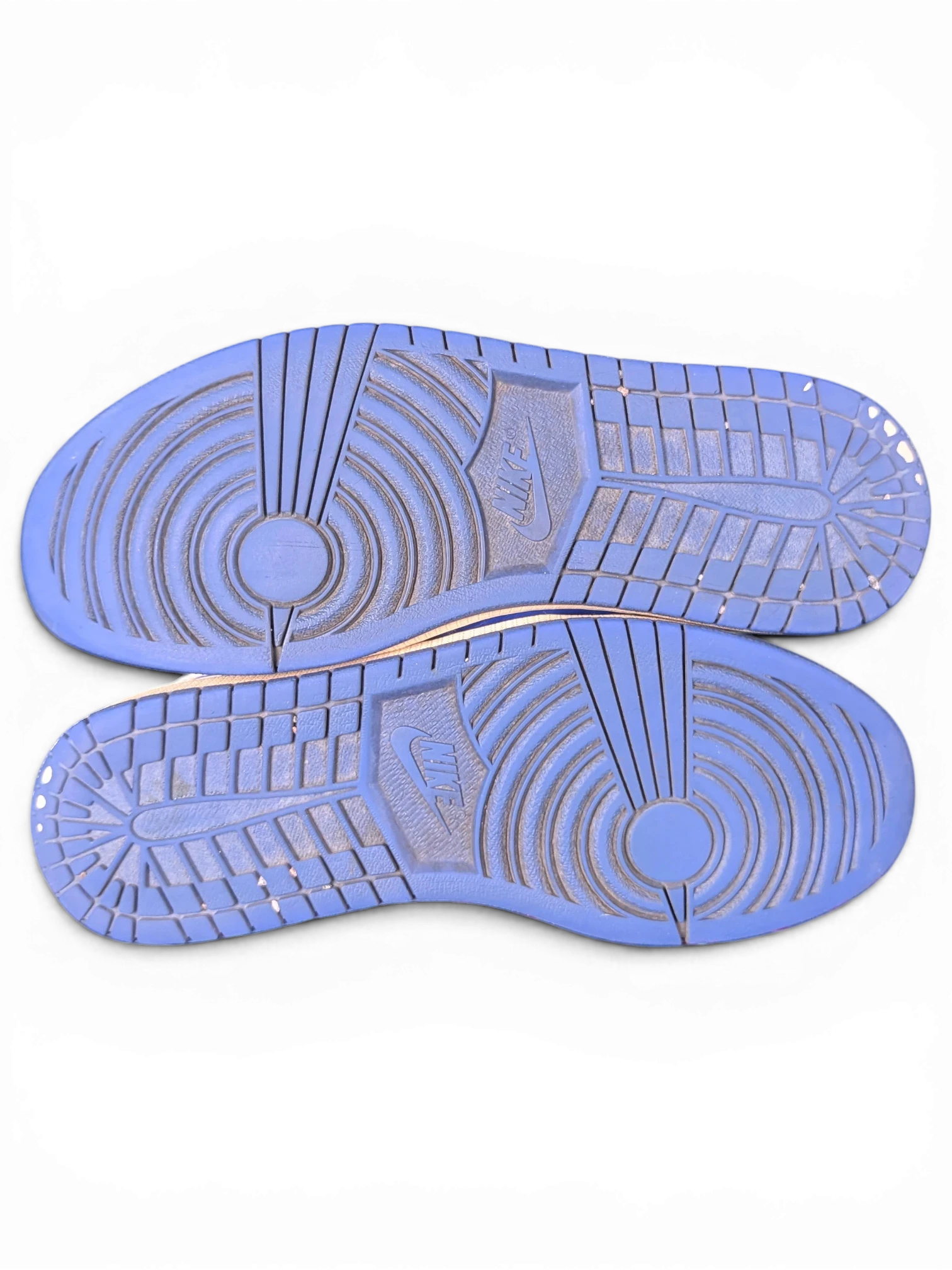 JAKE & IPI Air Jordan 1 Retro High Hyper Royal sneakers showing the blue rubber outsoles with traction patterns