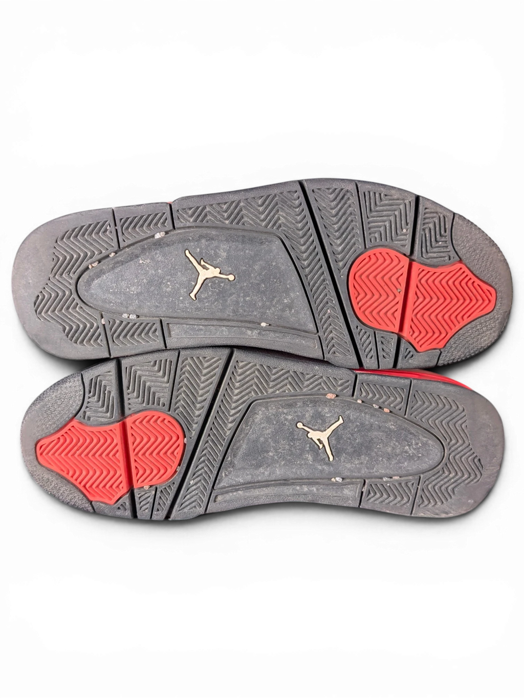 JAKE & IPI Air Jordan 4 Red Thunder sneakers showing black and red rubber outsoles with Jumpman logo detailing.