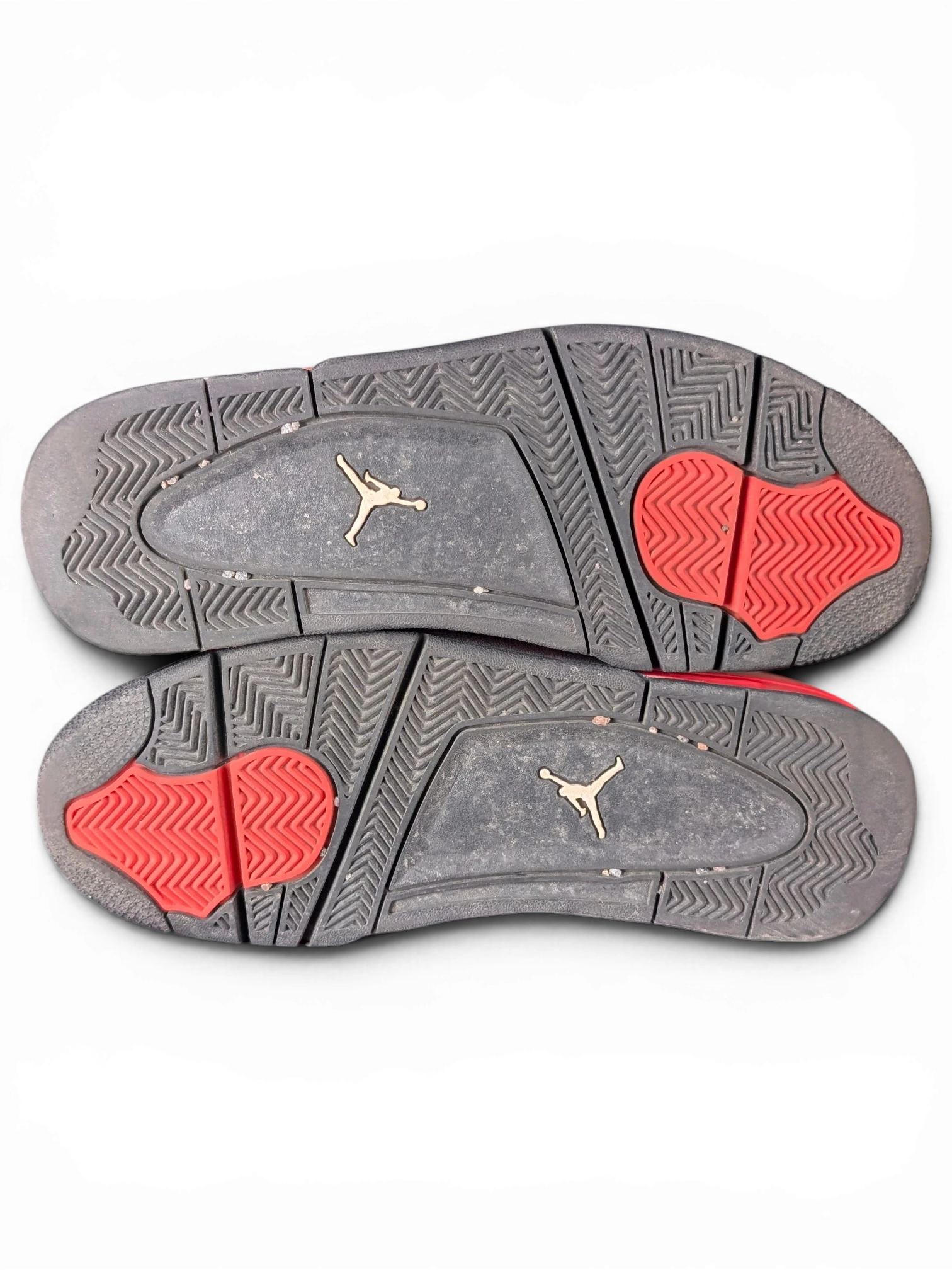 JAKE & IPI Air Jordan 4 Red Thunder sneakers showing black and red rubber outsoles with Jumpman logo detailing.
