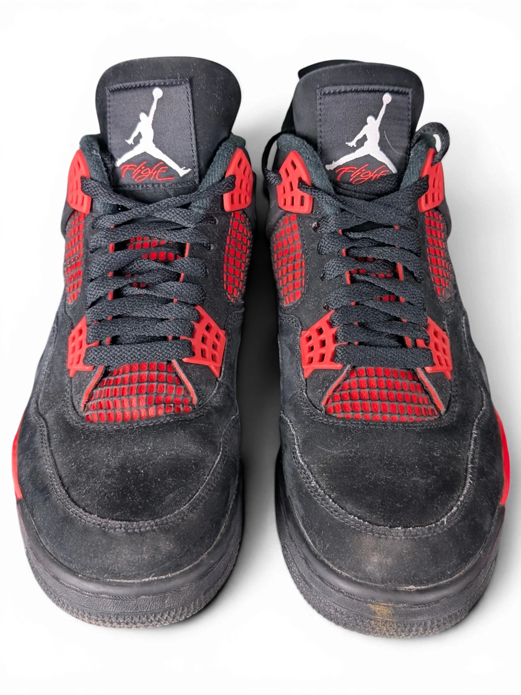 JAKE & IPI Air Jordan 4 Red Thunder sneakers in black nubuck with vibrant red accents and Jumpman tongue branding.