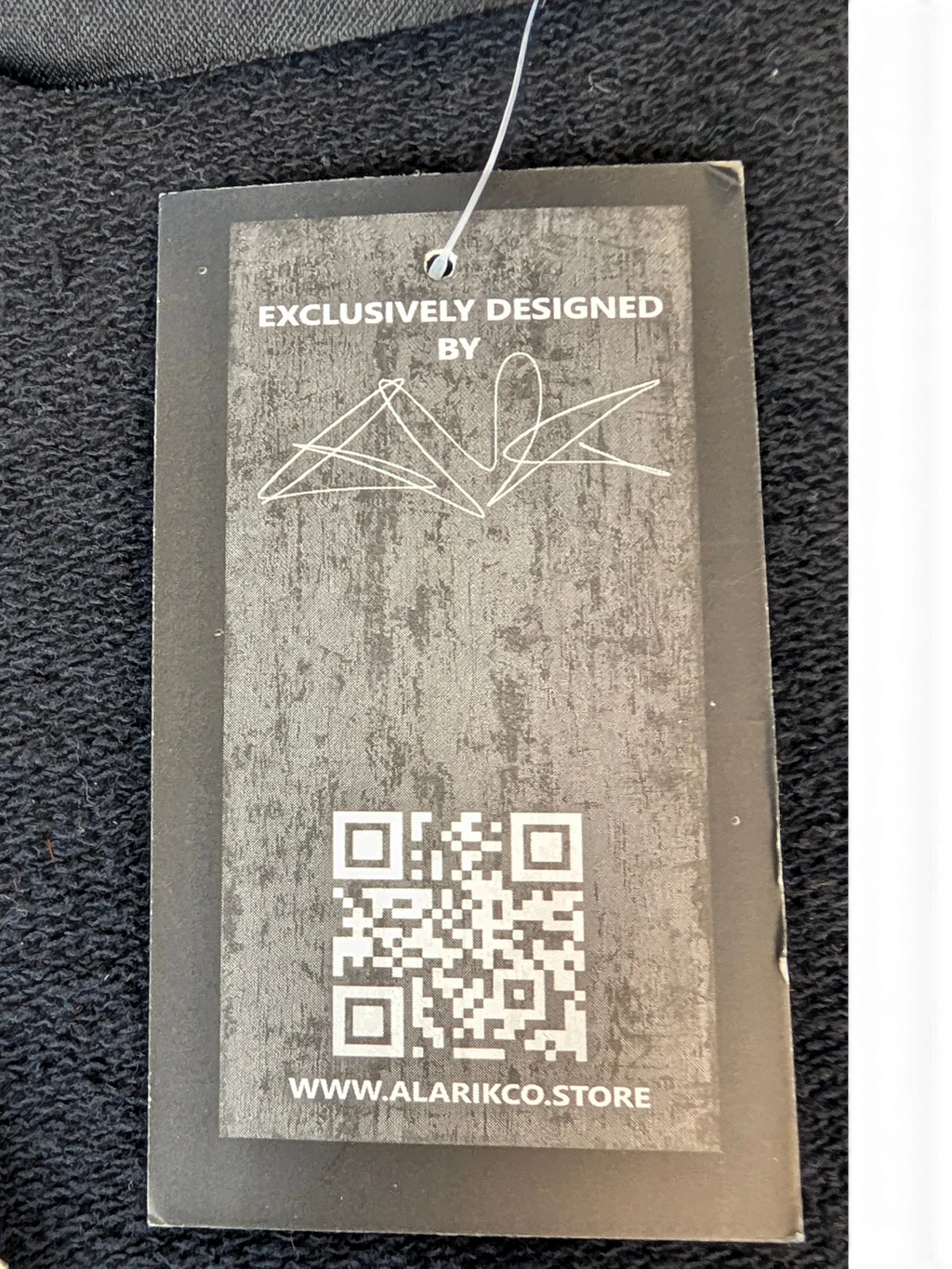 JAKE & IPI Alarikco track suit clothing tag with QR code and exclusive design branding on black fabric