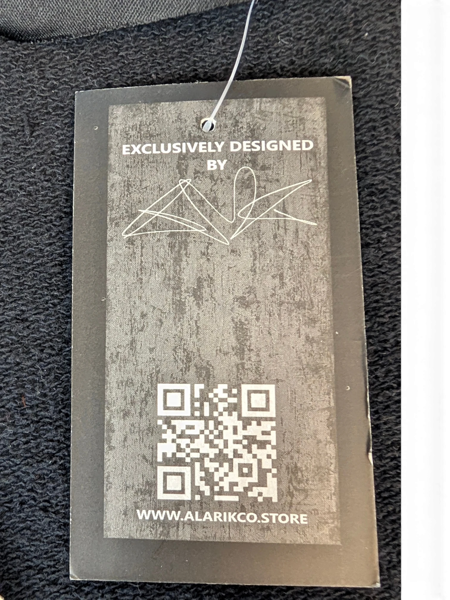 JAKE & IPI Alarikco track suit clothing tag with QR code and exclusive design branding on black fabric