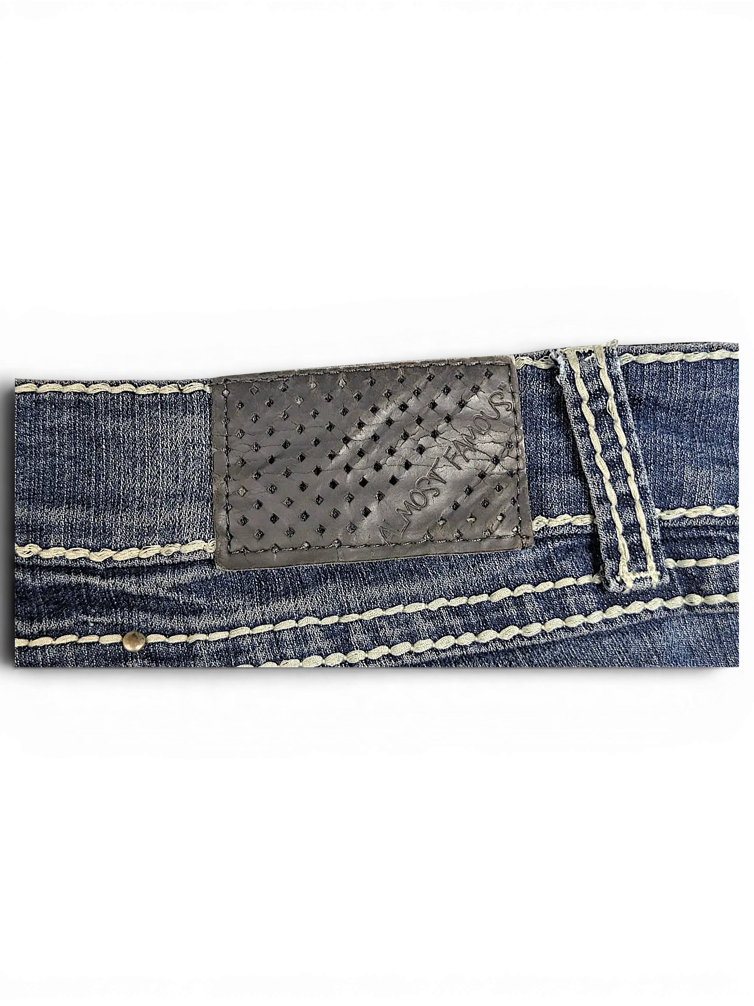 JAKE & IPI Almost Famous distressed blue denim jeans featuring a perforated leather back patch and thick stitching.