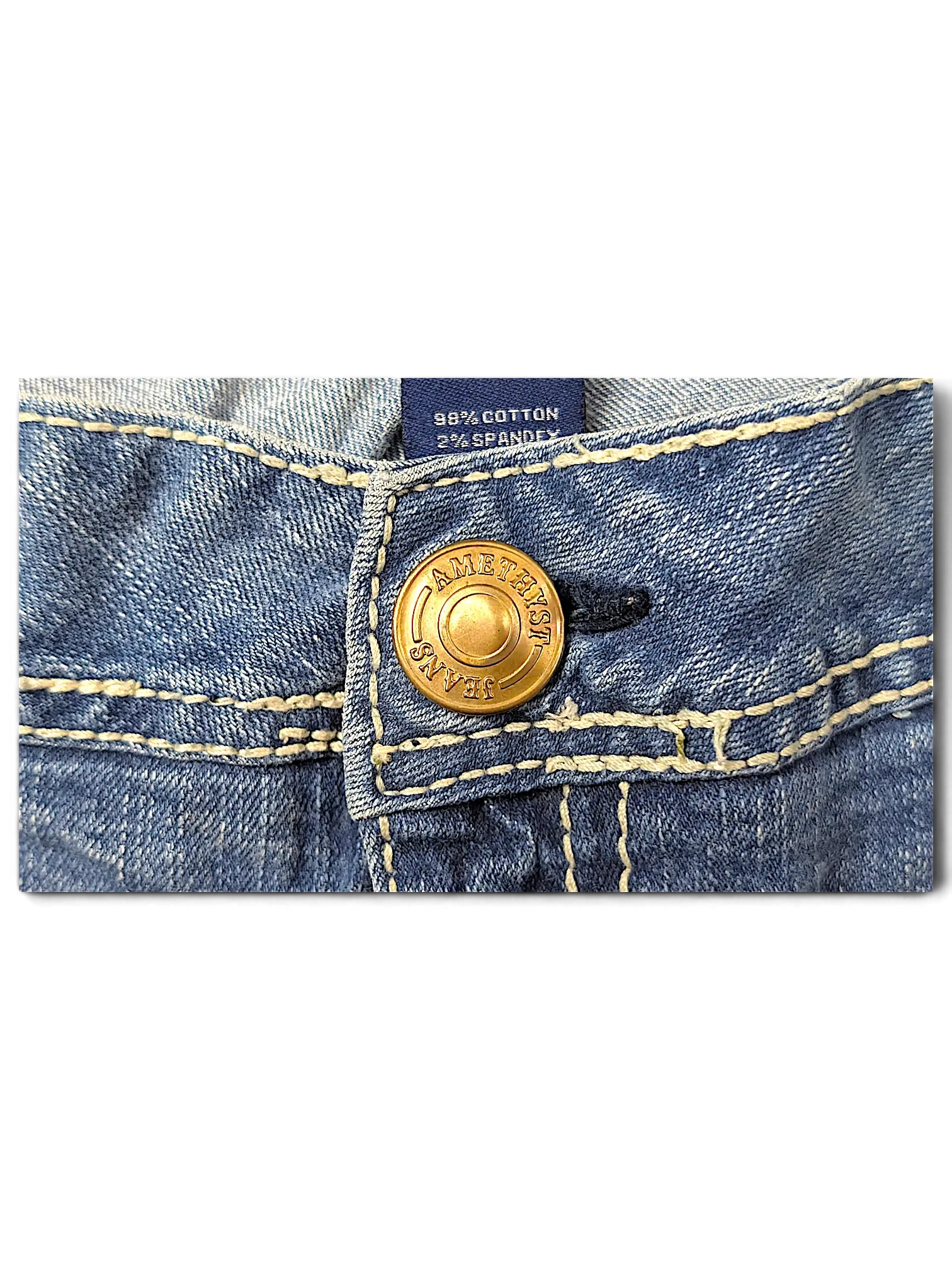 JAKE & IPI Amethyst Y2K jeans featuring a gold-tone branded button and contrast stitching on blue denim fabric.