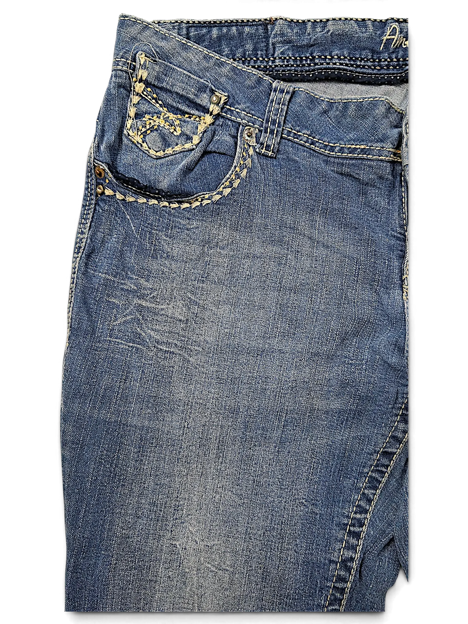 JAKE & IPI Amethyst Y2K blue denim jeans featuring decorative cream stitching and metal stud details on the pocket.