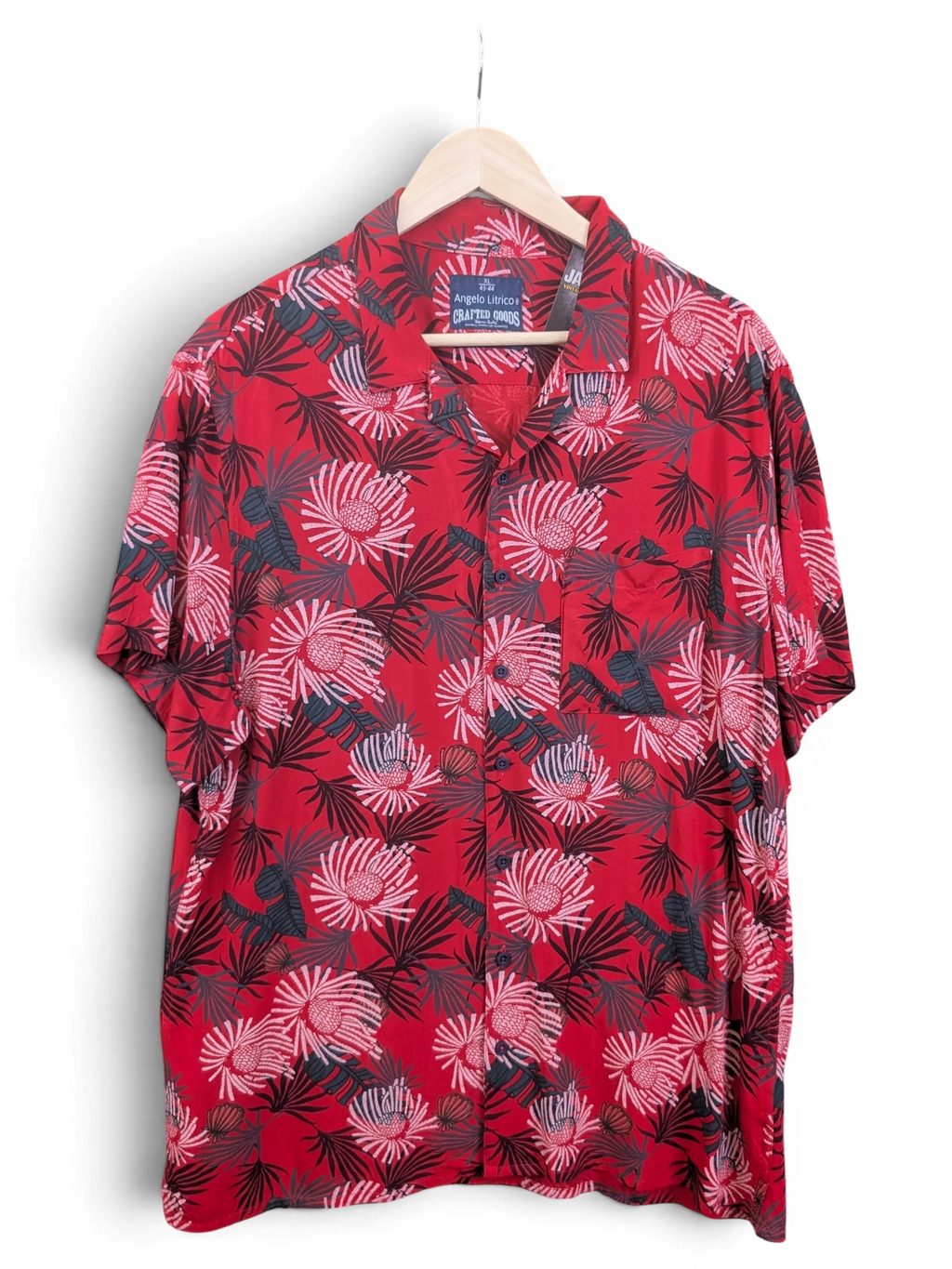 JAKE & IPI Angelo Litrico red Hawaiian shirt with a tropical floral print and short sleeves on a wooden hanger