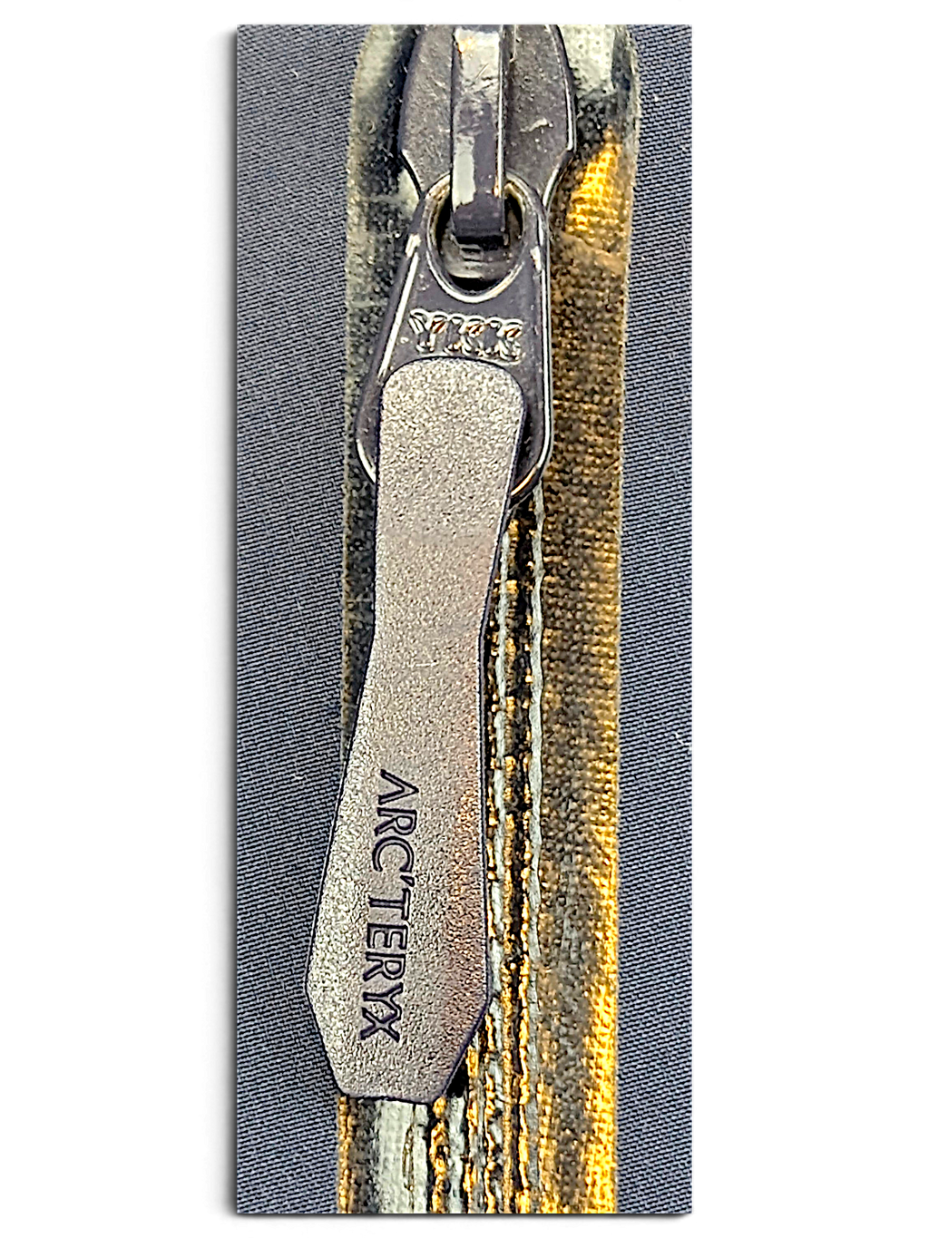 Arc'teryx jacket zip detail showing visible wear and discolouration