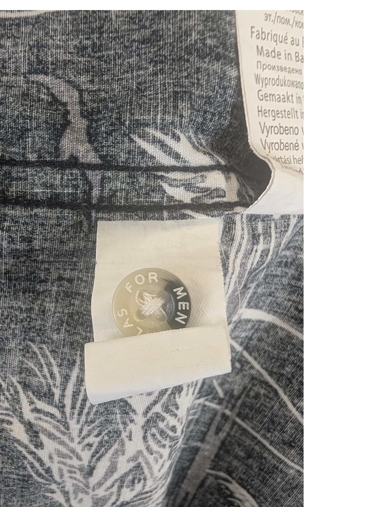 JAKE & IPI Atlas For Men Hawaiian shirt spare button detail with branded engraving on a grey and white patterned fabric