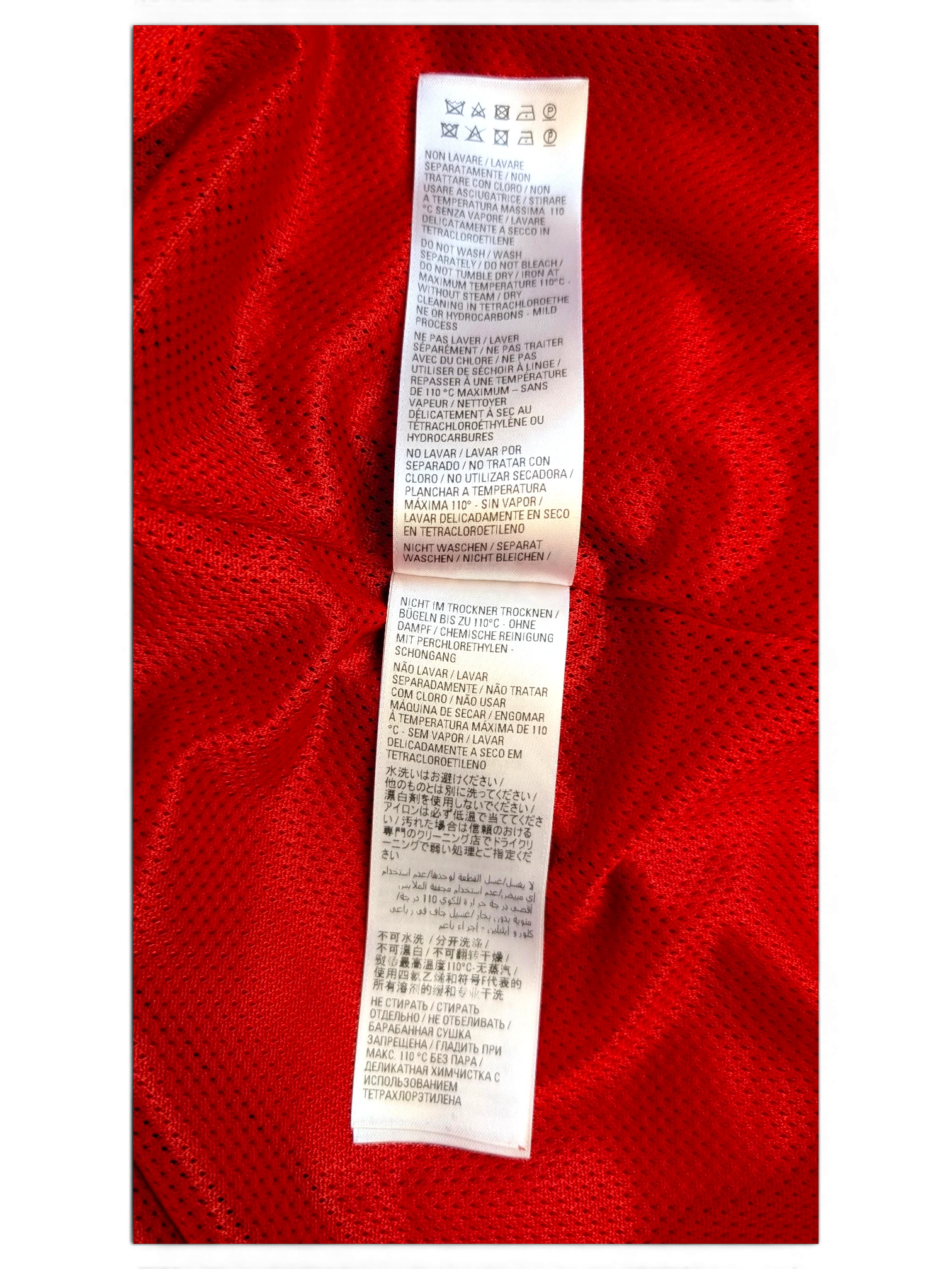 JAKE & IPI Balenciaga x Adidas clothing care label with multi-language washing instructions on red fabric