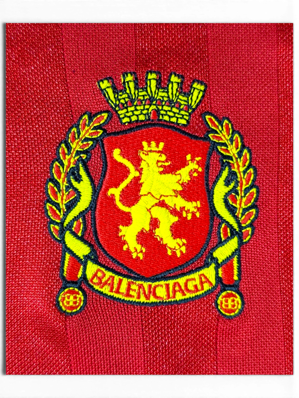 JAKE & IPI red Balenciaga x Adidas jersey featuring a detailed yellow and red embroidered lion crest logo.