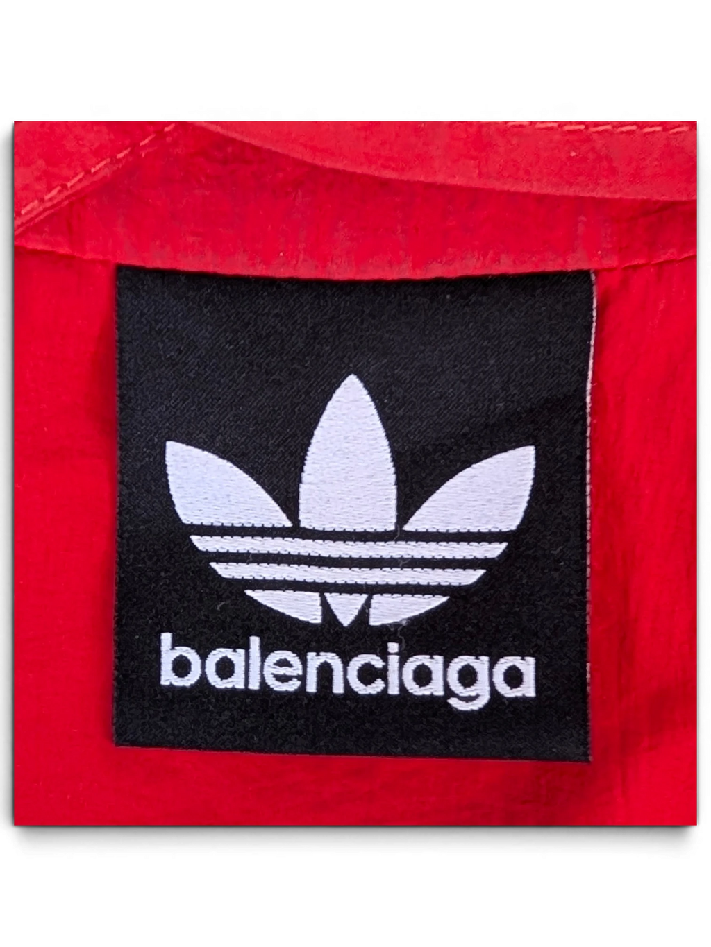 JAKE & IPI Balenciaga x Adidas collaboration red garment featuring a black embroidered brand logo patch