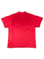 Back view of a red JAKE & IPI Balenciaga x Adidas jersey featuring vertical stripes and white shoulder stripes.