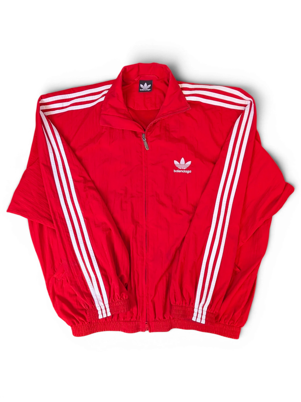 JAKE & IPI Balenciaga x Adidas red zip-up track jacket with white three-stripe detailing and dual branding.