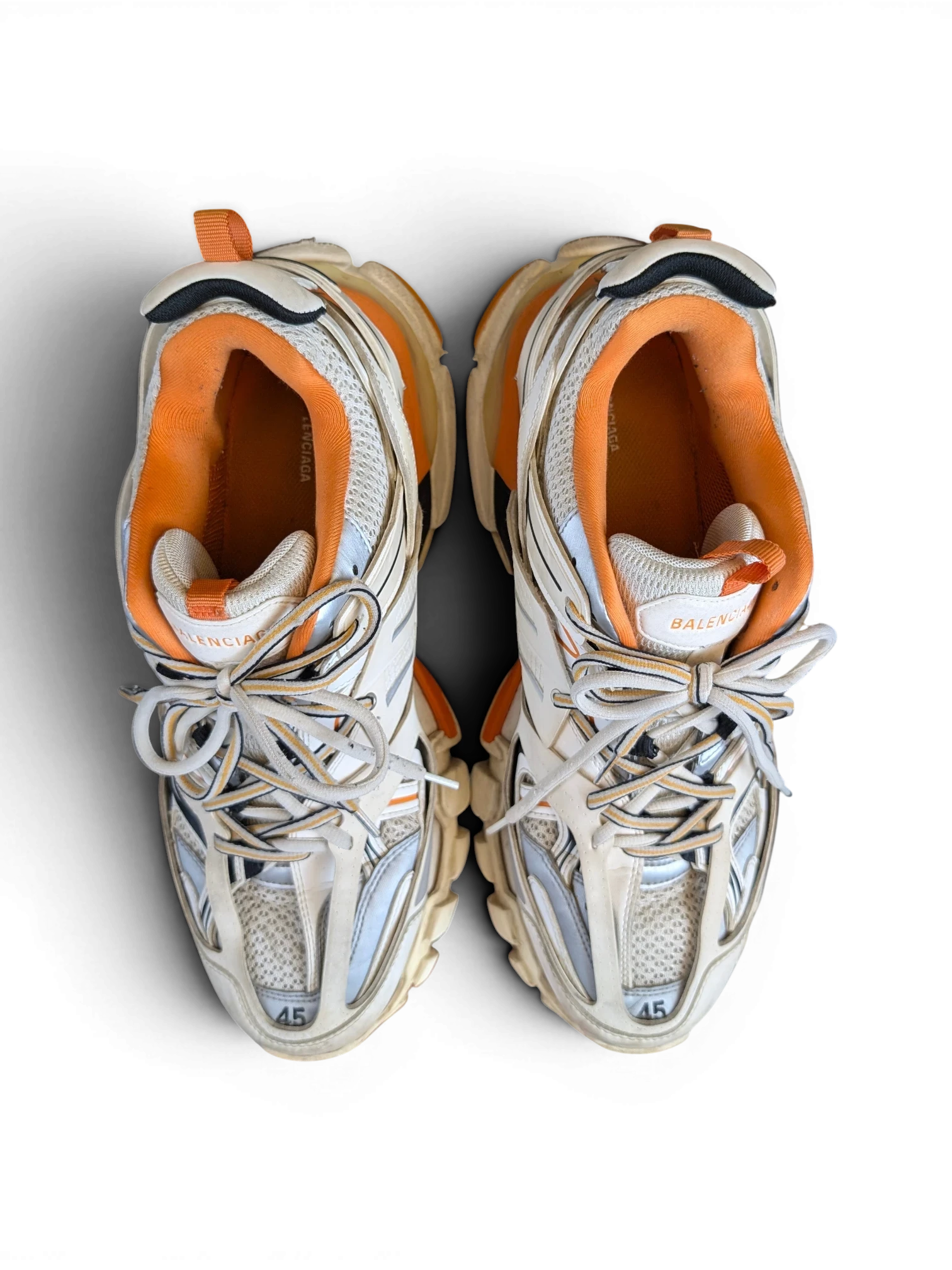 JAKE & IPI Balenciaga Track sneakers in white, grey, and orange with a layered, rugged design viewed from above.