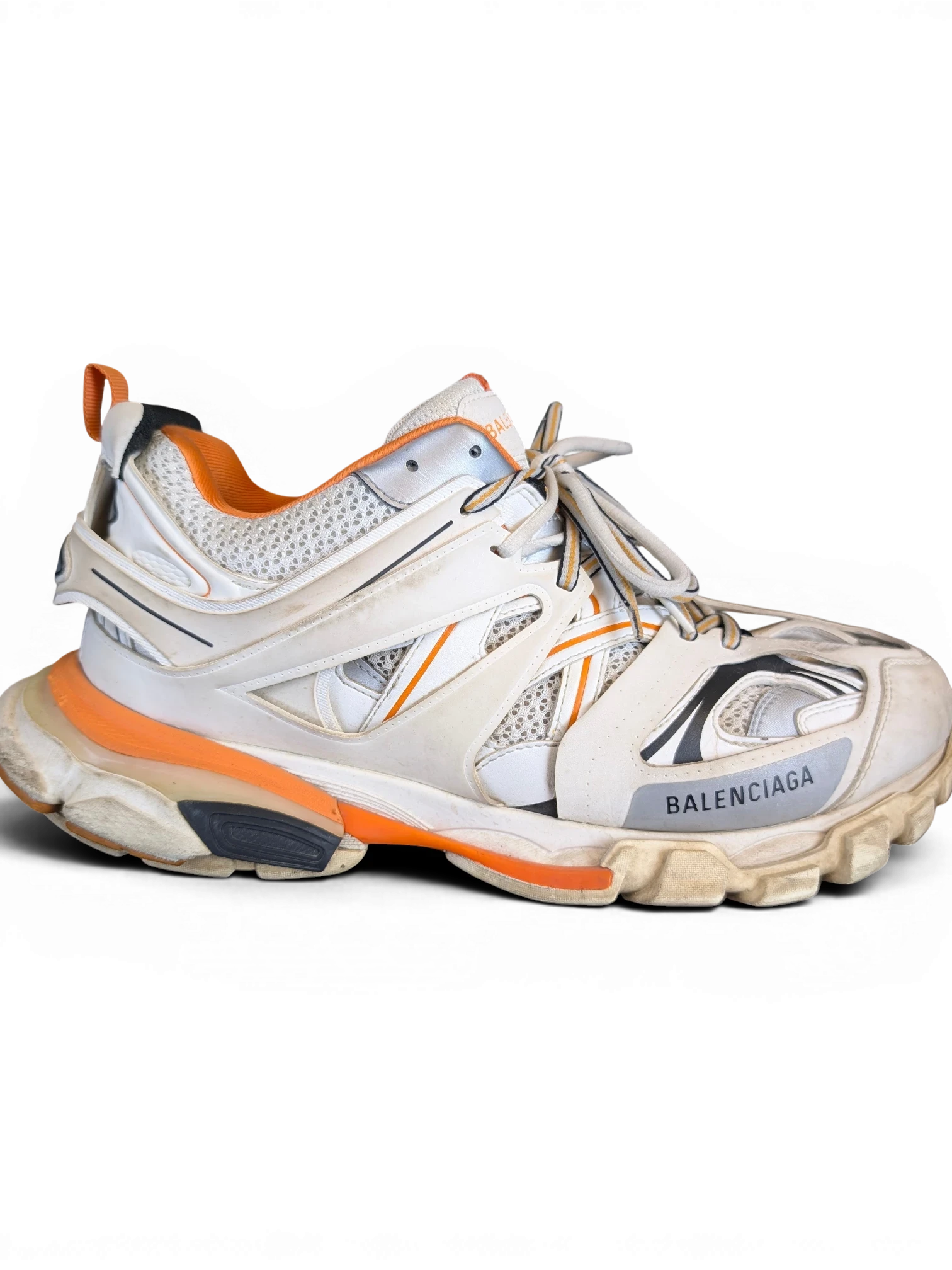 JAKE & IPI Balenciaga Track sneakers in white, grey, and orange with a rugged, layered design and mesh detailing.