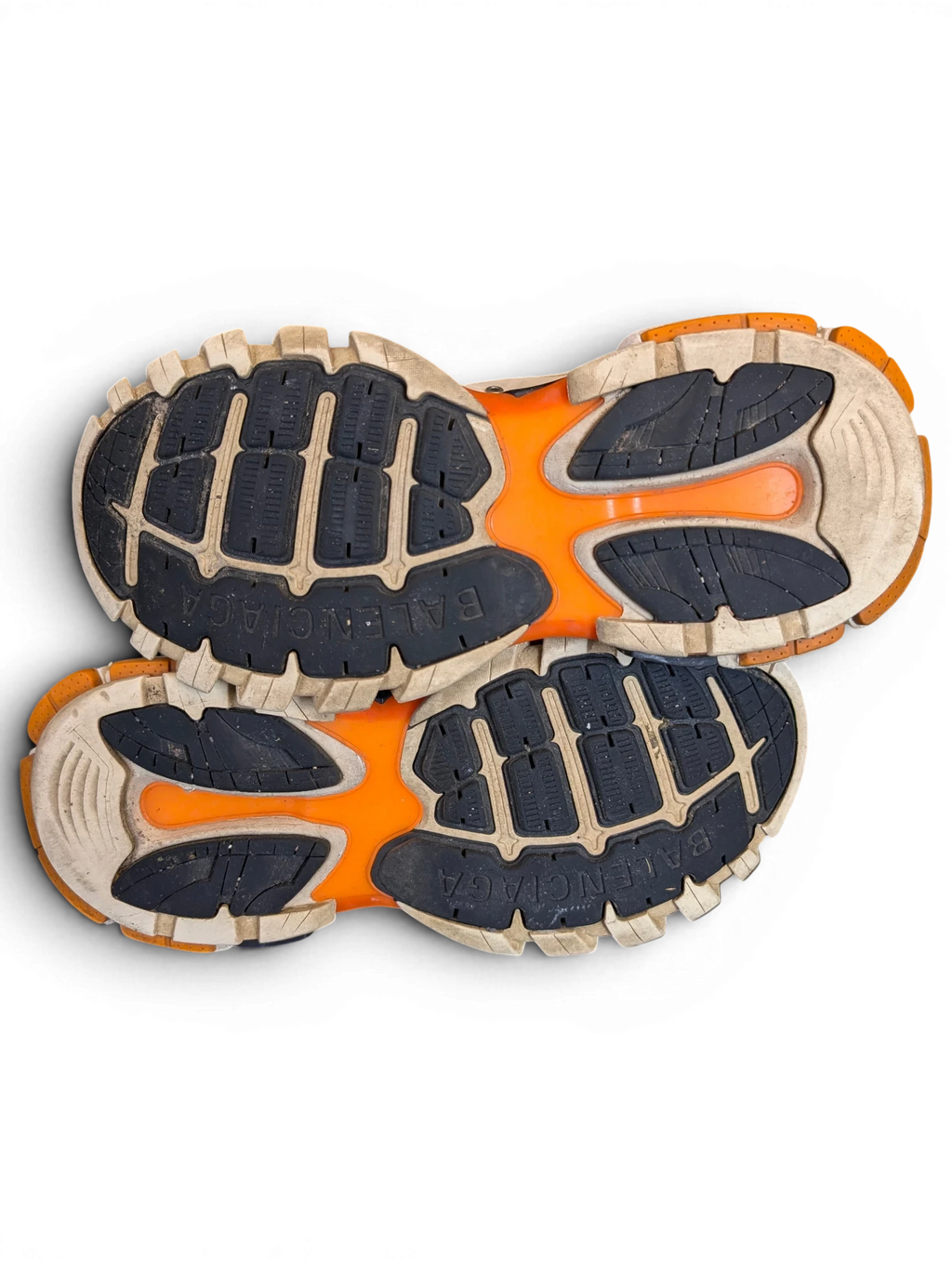 JAKE & IPI Balenciaga Track sneakers featuring a white, grey, and orange rugged rubber outsole on a black background.