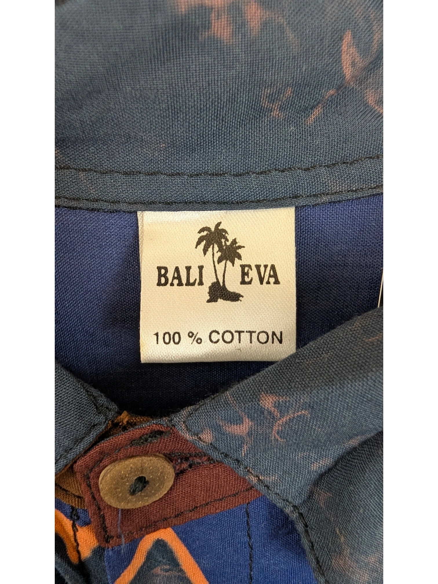 JAKE & IPI Bali Eva Hawaiian shirt label showing 100% cotton material and blue tropical print fabric