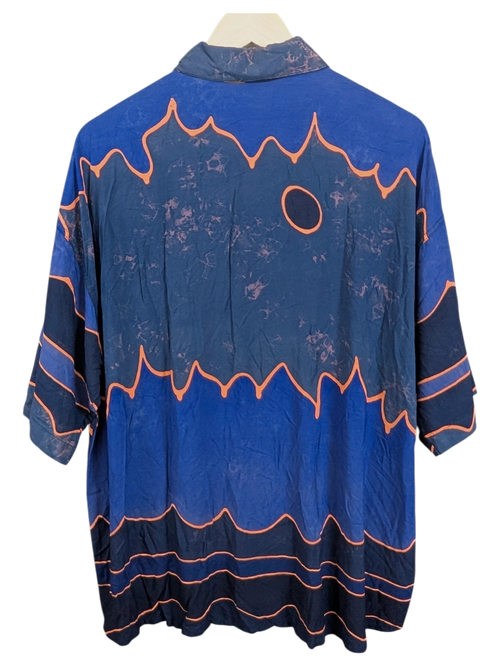 JAKE & IPI Bali Eva Hawaiian shirt in blue with orange abstract wave patterns and a circular motif on the back.