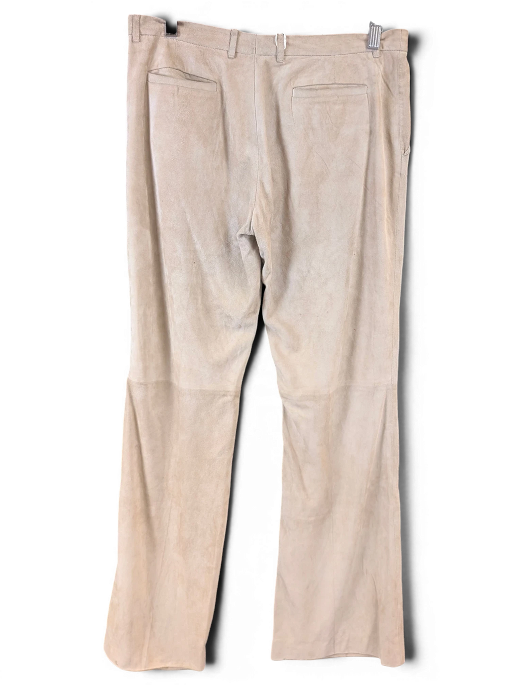 JAKE & IPI beige suede leather pants with back pockets hanging on a wooden hanger against a black background