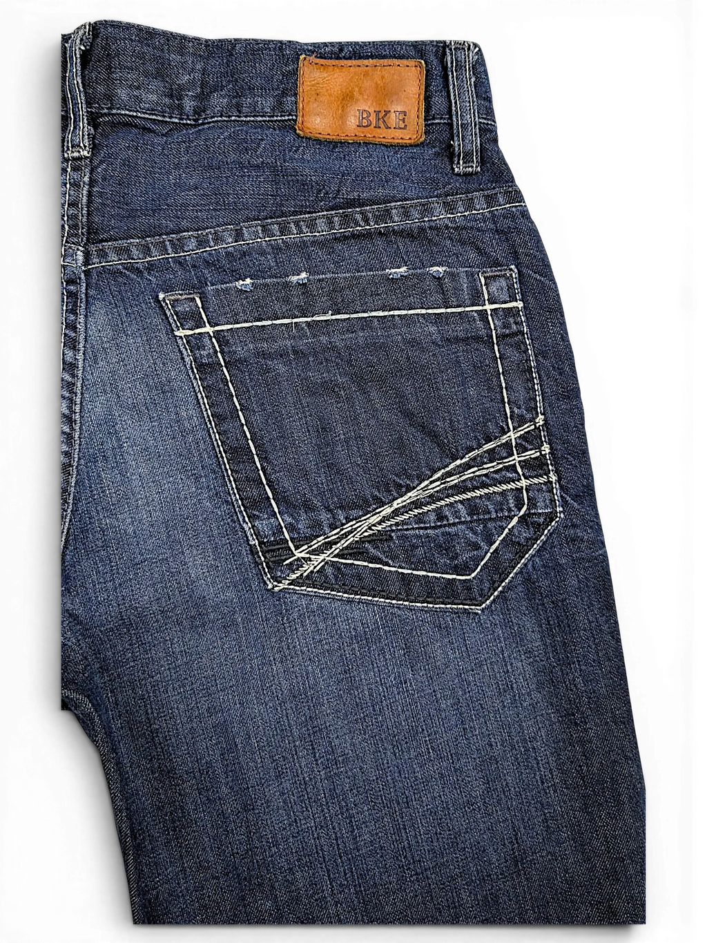 JAKE & IPI BKE Denim Carter jeans in dark wash with distressed back pocket and tan leather brand patch