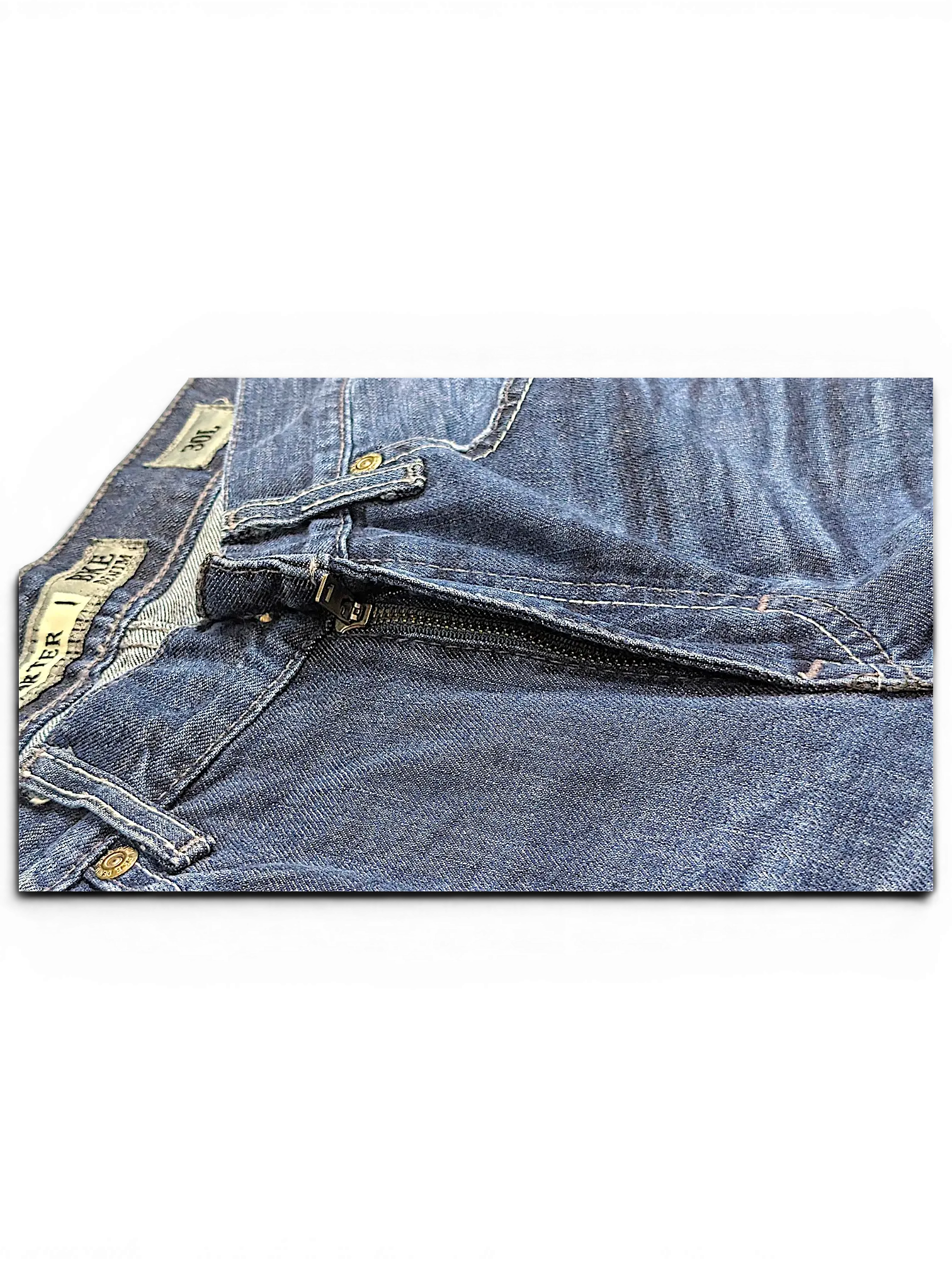Close-up of JAKE & IPI BKE Denim Carter 30L blue jeans featuring a metal zipper fly and branded rivets.