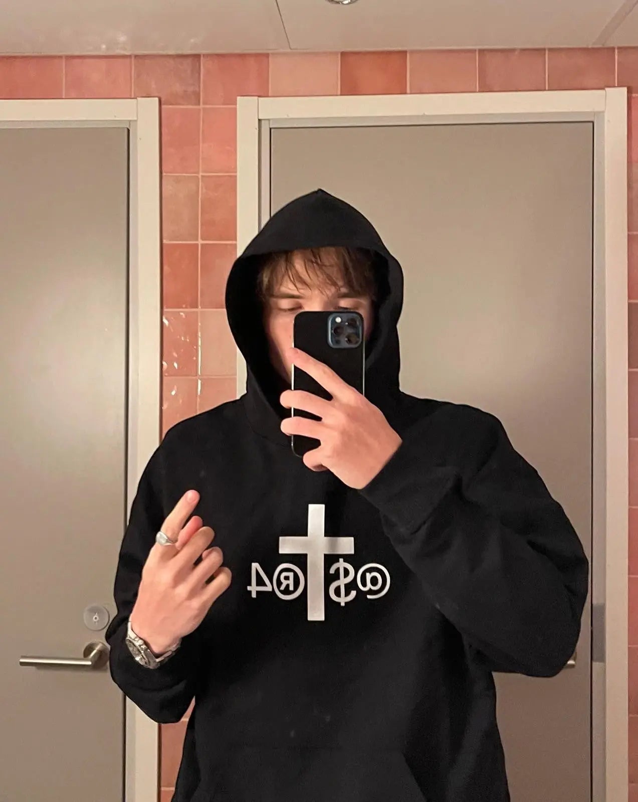 JAKE & IPI black IBE Astra hoodie with white cross and text graphic on the chest worn by a person in a mirror selfie