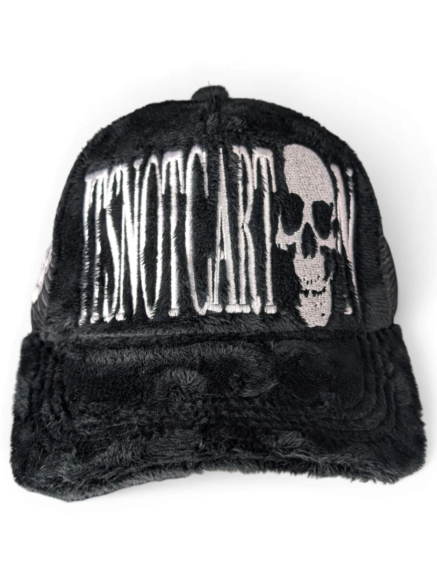 JAKE & IPI black faux fur trucker cap featuring white embroidered Itsnotcartoon text and a skull graphic