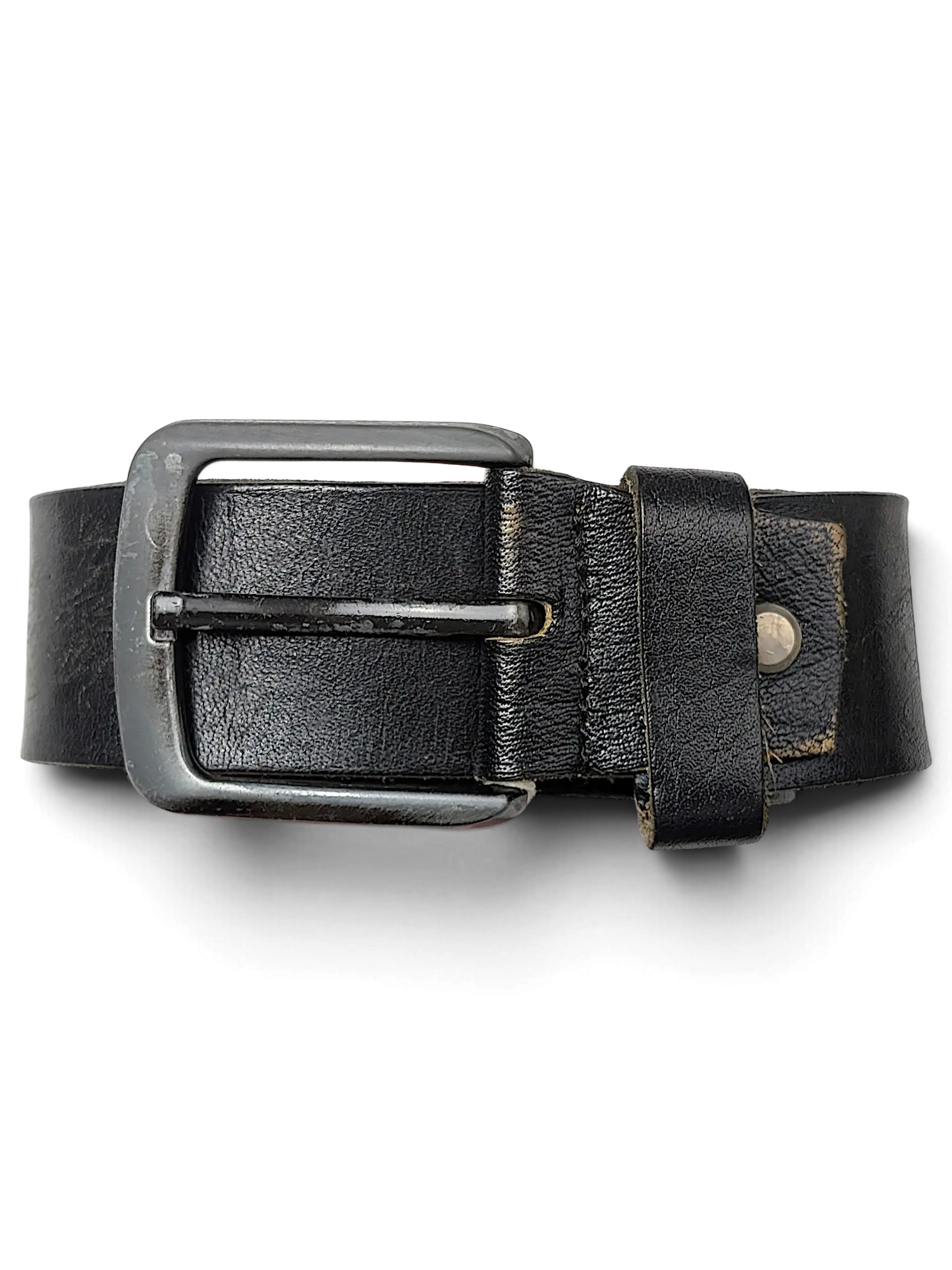 JAKE & IPI black leather belt with a silver metal buckle held by a hand against a black background