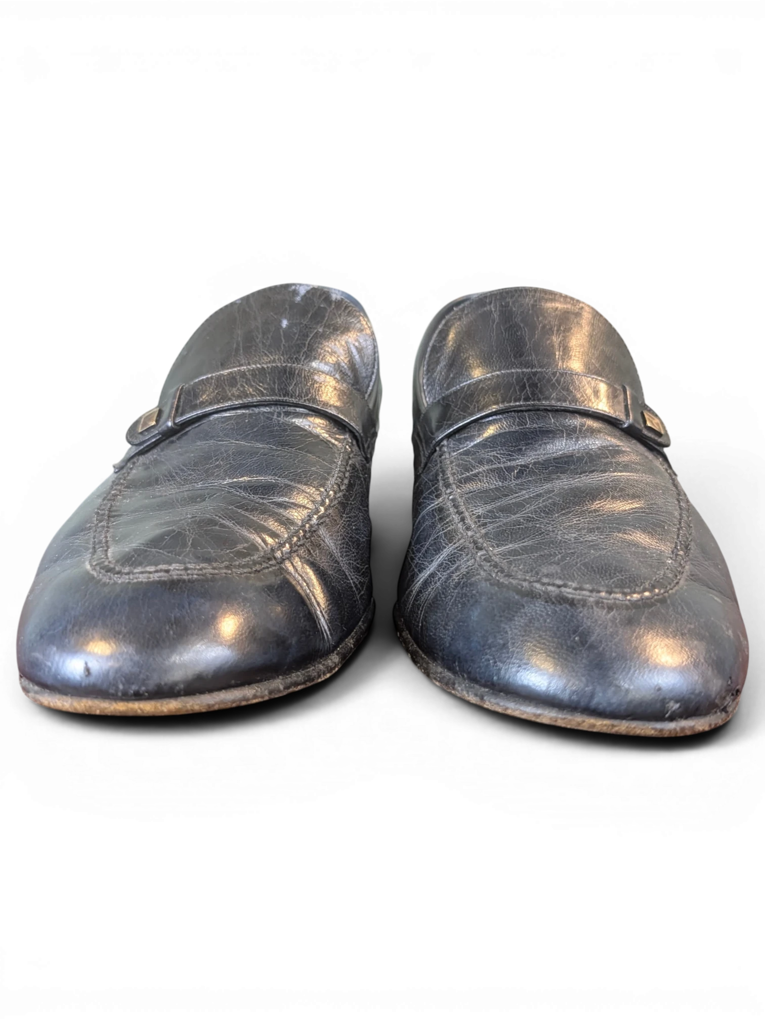 JAKE & IPI black leather loafers with a classic strap detail and textured finish, front view.