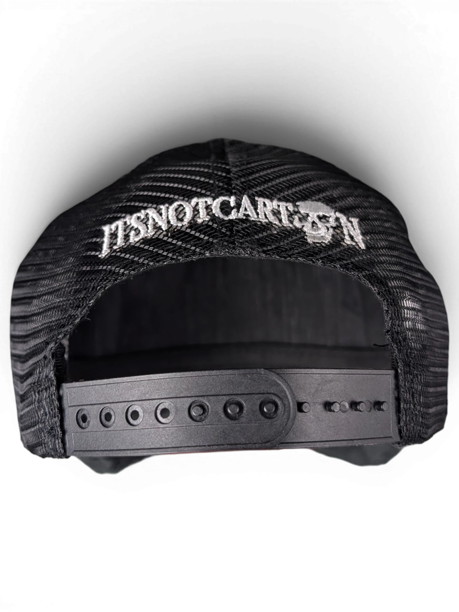JAKE & IPI black mesh snapback cap featuring white ITSNOTCARTOON embroidery with a skull detail on the back