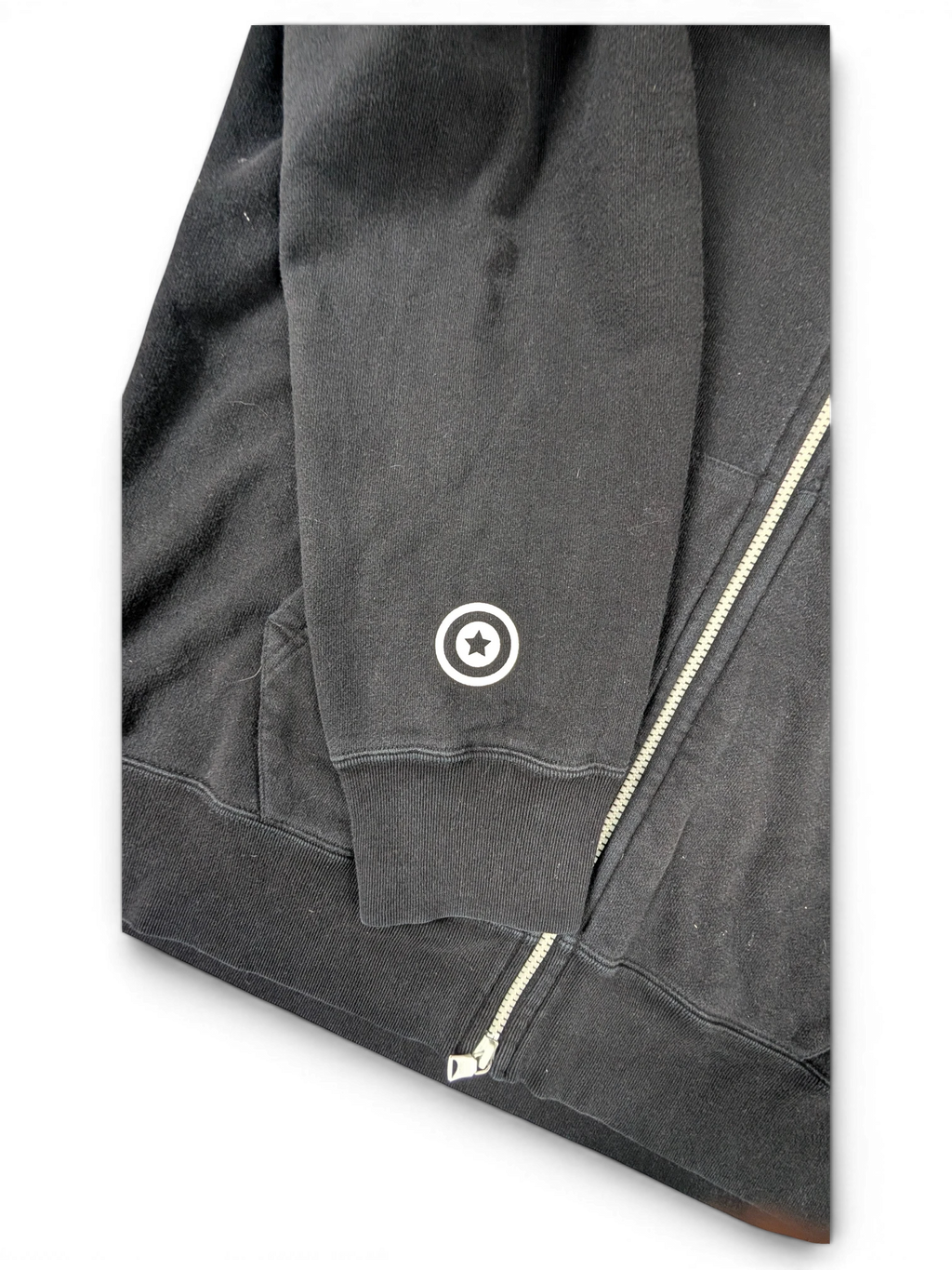 JAKE & IPI black cotton zip-up hoodie featuring a white star logo detail on the sleeve cuff.