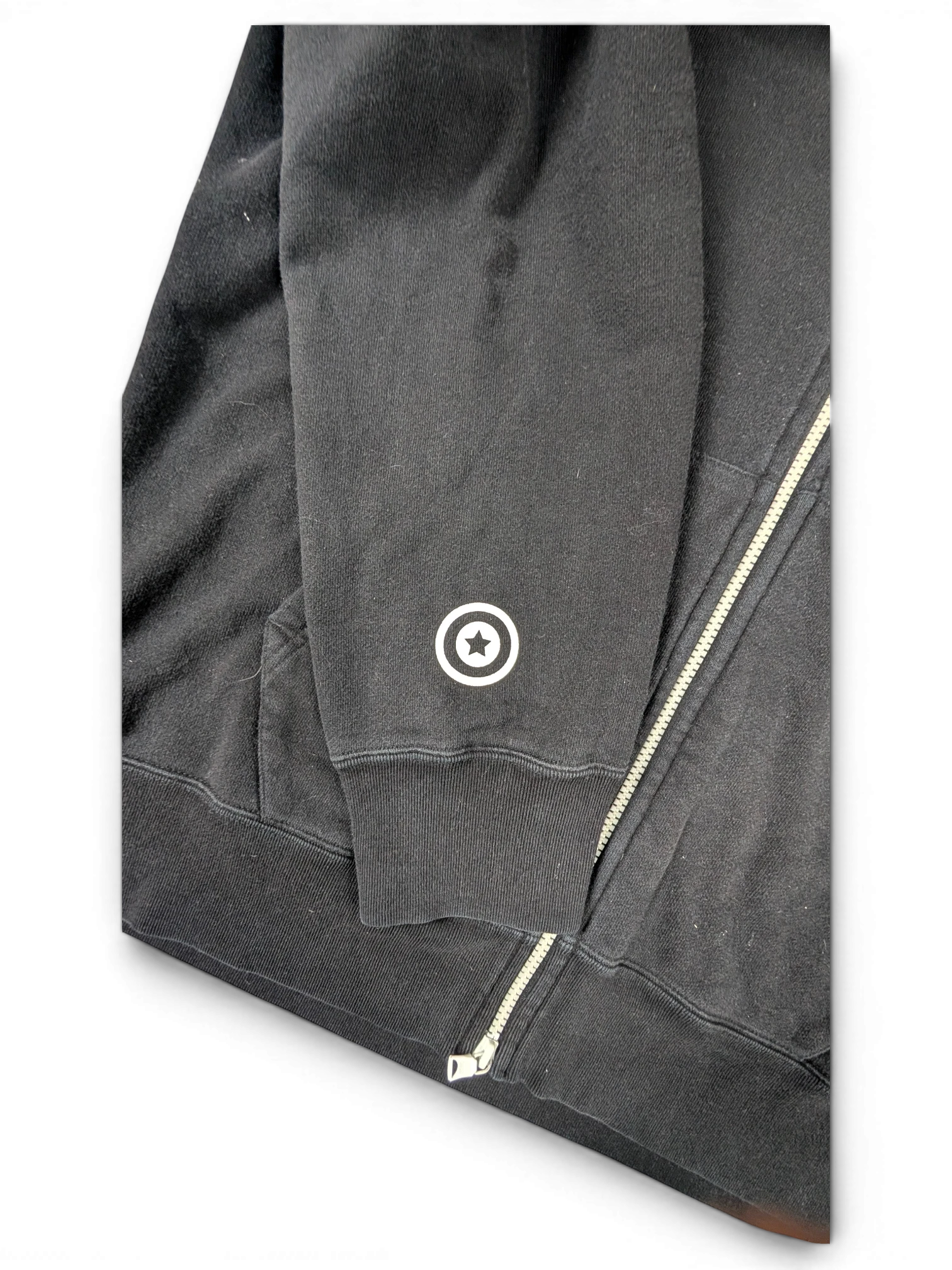 JAKE & IPI black cotton zip-up hoodie featuring a white star logo detail on the sleeve cuff.