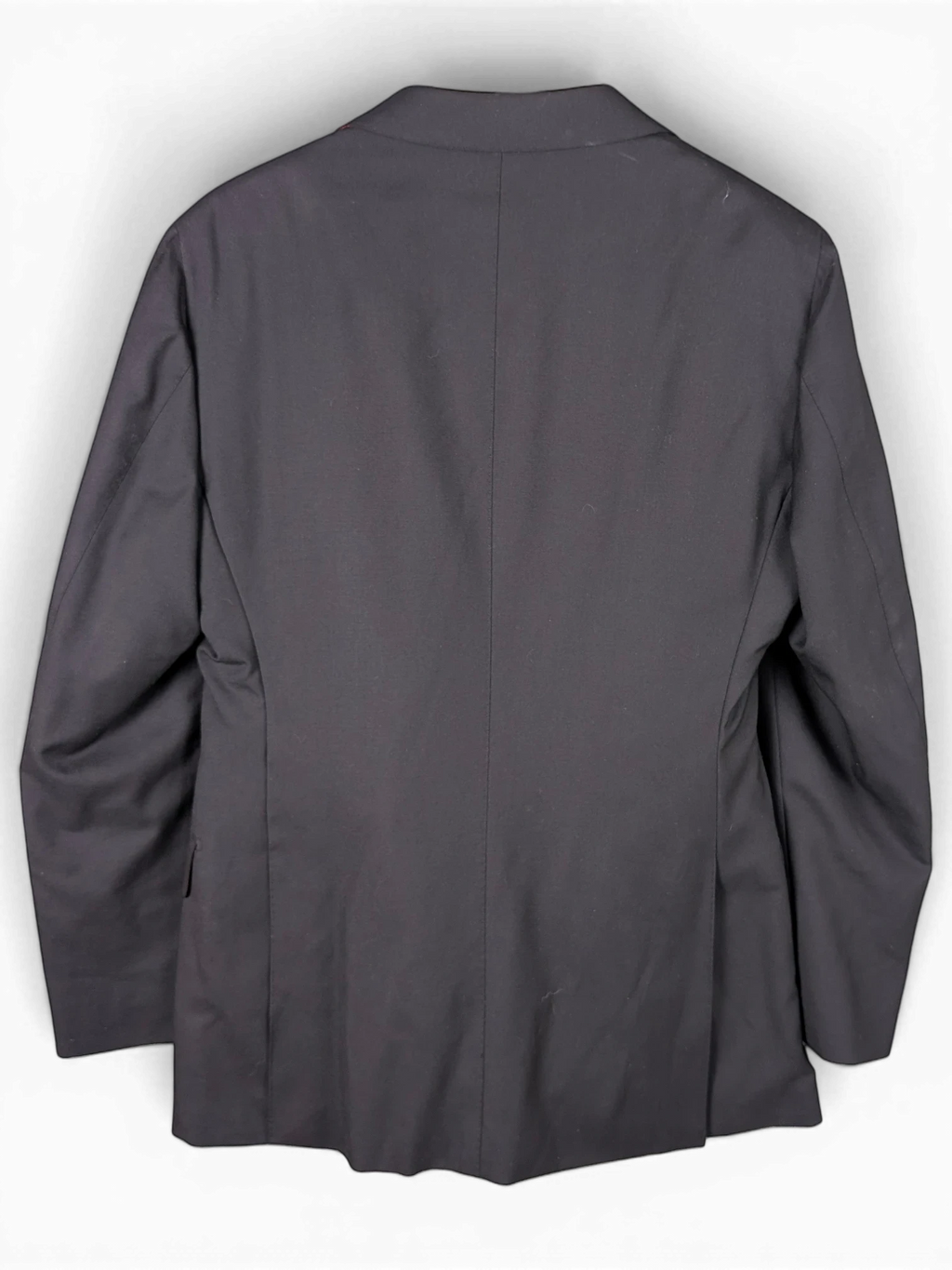 Back view of a black Suitsupply suit jacket hanging on a wooden hanger from JAKE & IPI