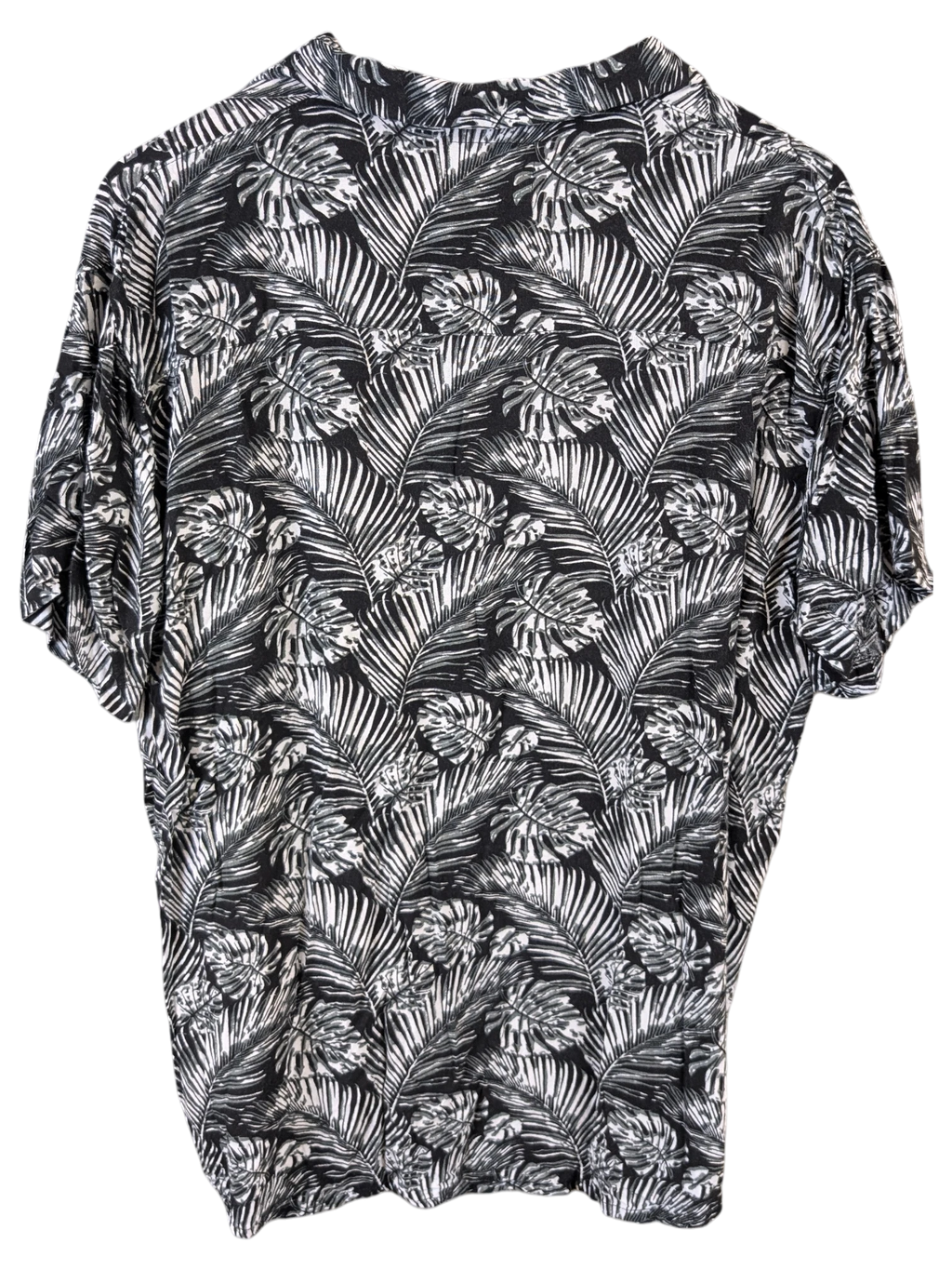 JAKE & IPI black and white Hawaiian shirt featuring a tropical palm leaf print on a wooden hanger