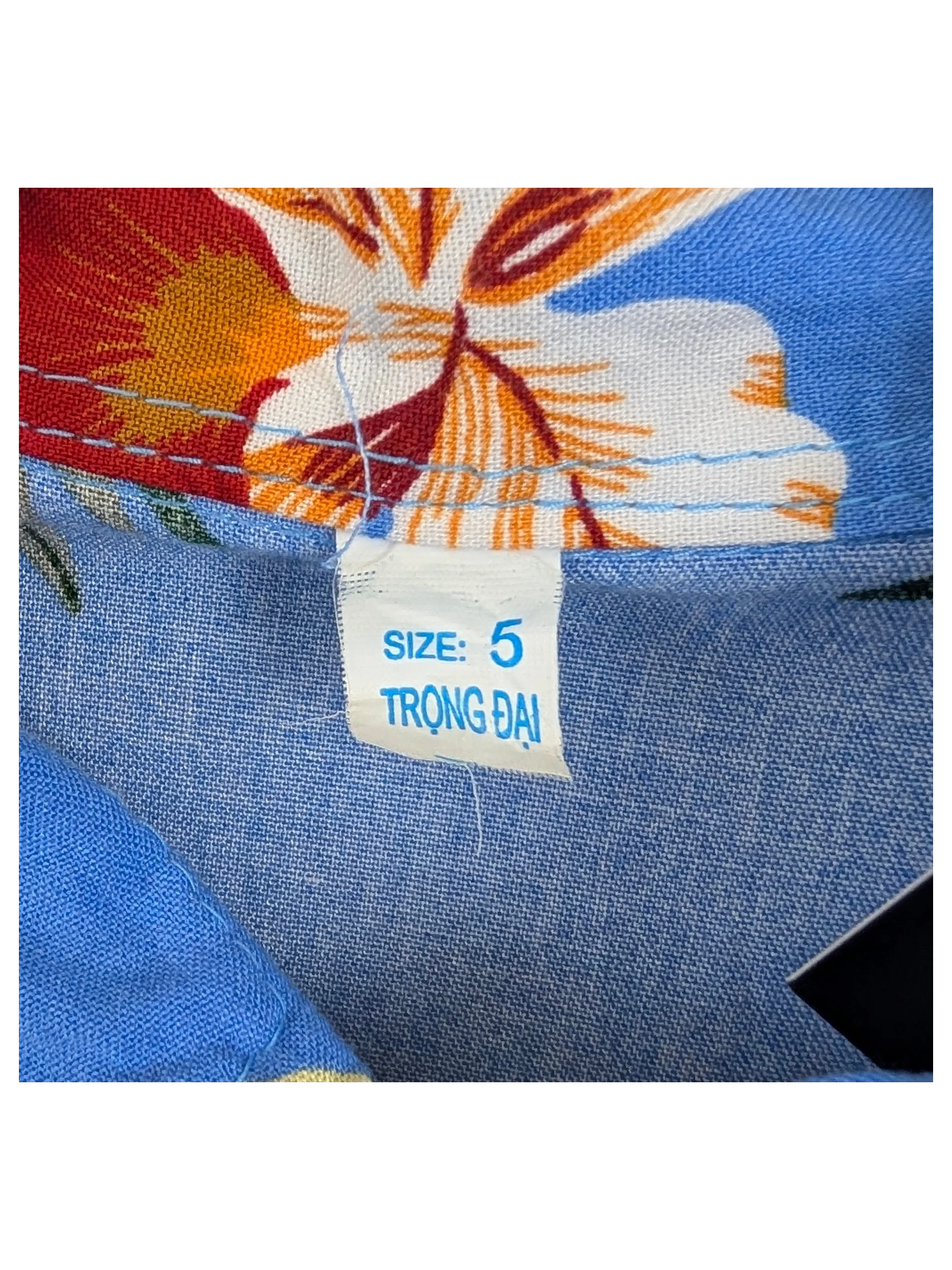 JAKE & IPI blue Hawaiian shirt with a vibrant floral print and size 5 label hanging on a wooden hanger