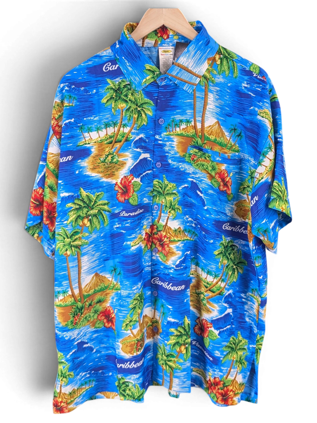 JAKE & IPI Rima Hawaiian shirt in blue featuring a vibrant tropical island print with palm trees and hibiscus flowers