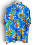 JAKE & IPI Rima Hawaiian shirt in blue featuring a vibrant tropical island print with palm trees and hibiscus flowers