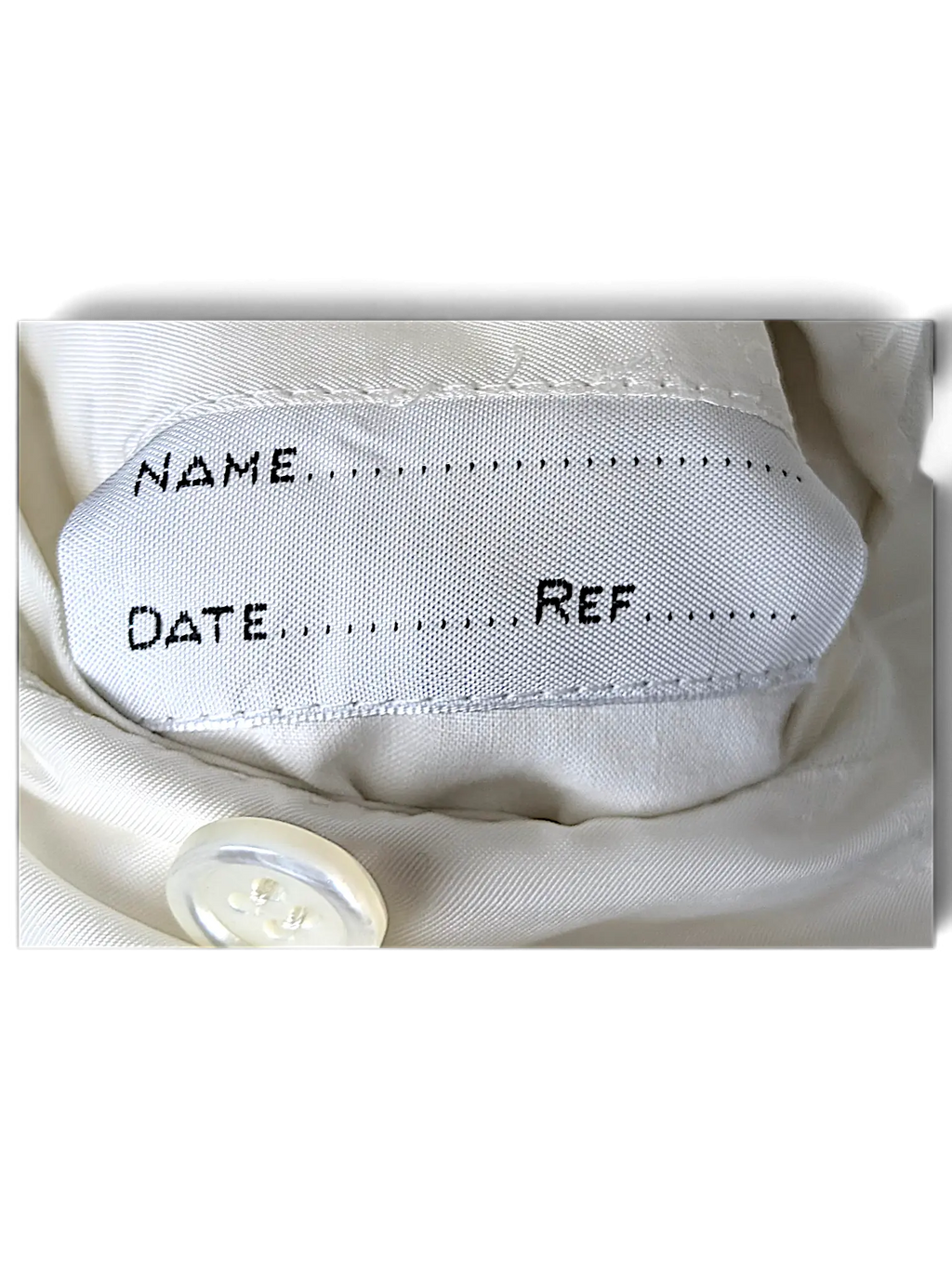 JAKE & IPI Brioni linen suit interior garment label with name, date, and reference fields on white fabric