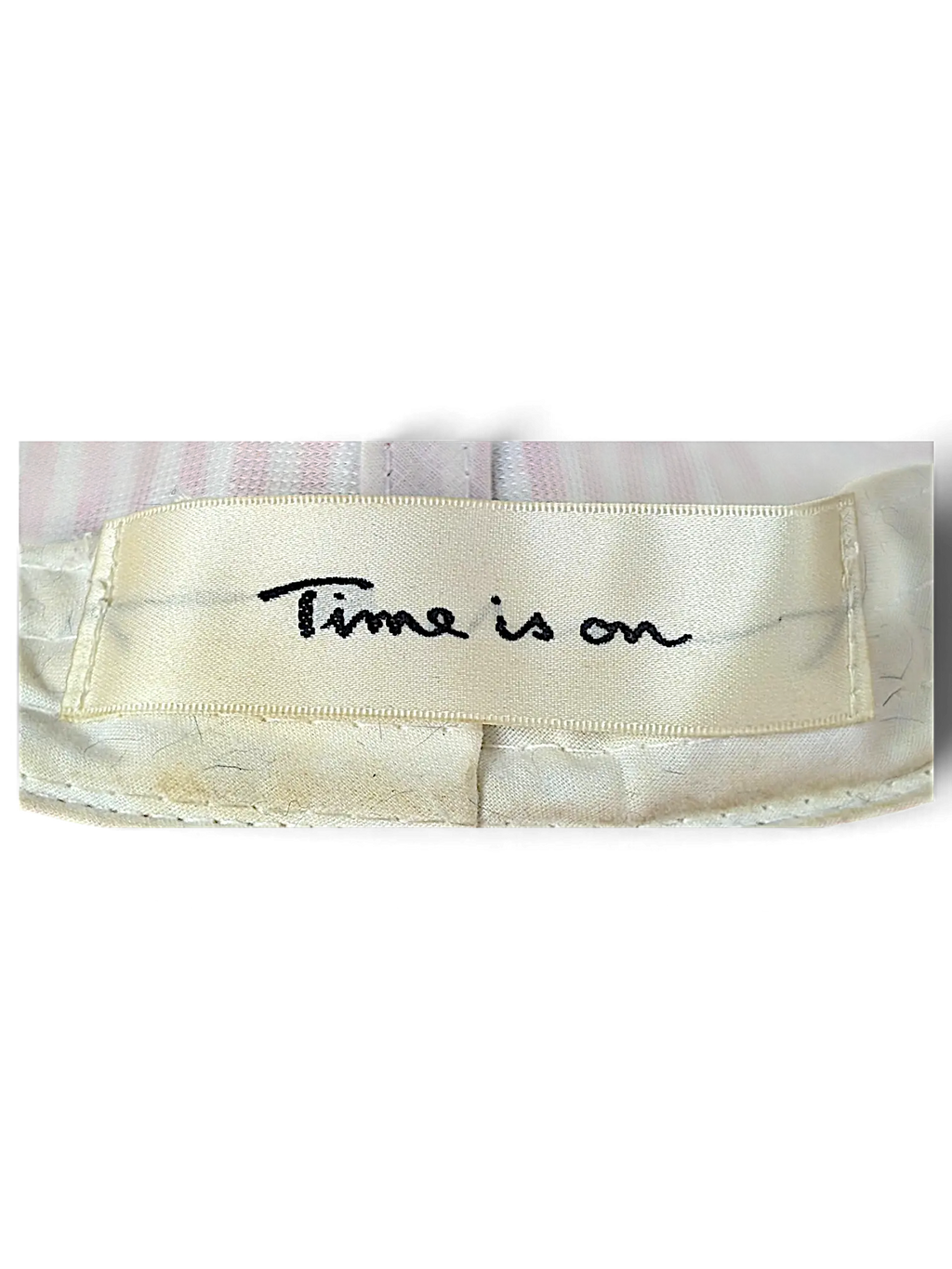 JAKE & IPI bucket hat interior cream fabric label with black embroidered Time is on text