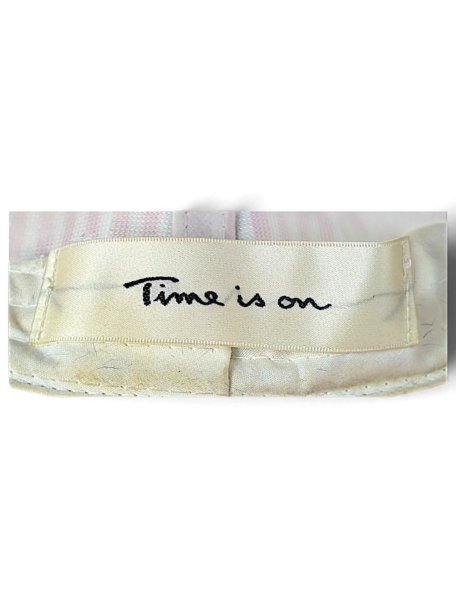 JAKE & IPI bucket hat interior cream fabric label with black embroidered Time is on text