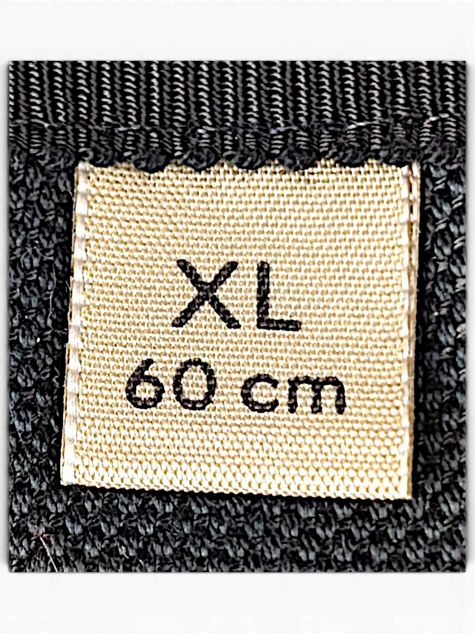 JAKE & IPI bucket hat size label showing XL and 60 cm on a textured black fabric background